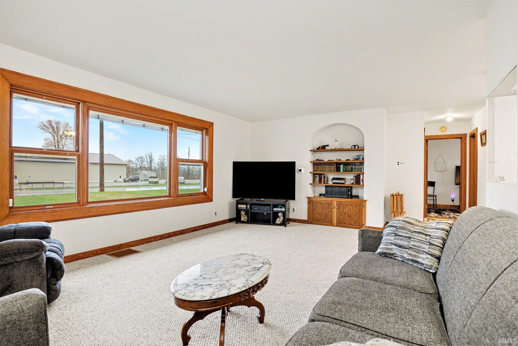 Living area with light colored carpet and built in features