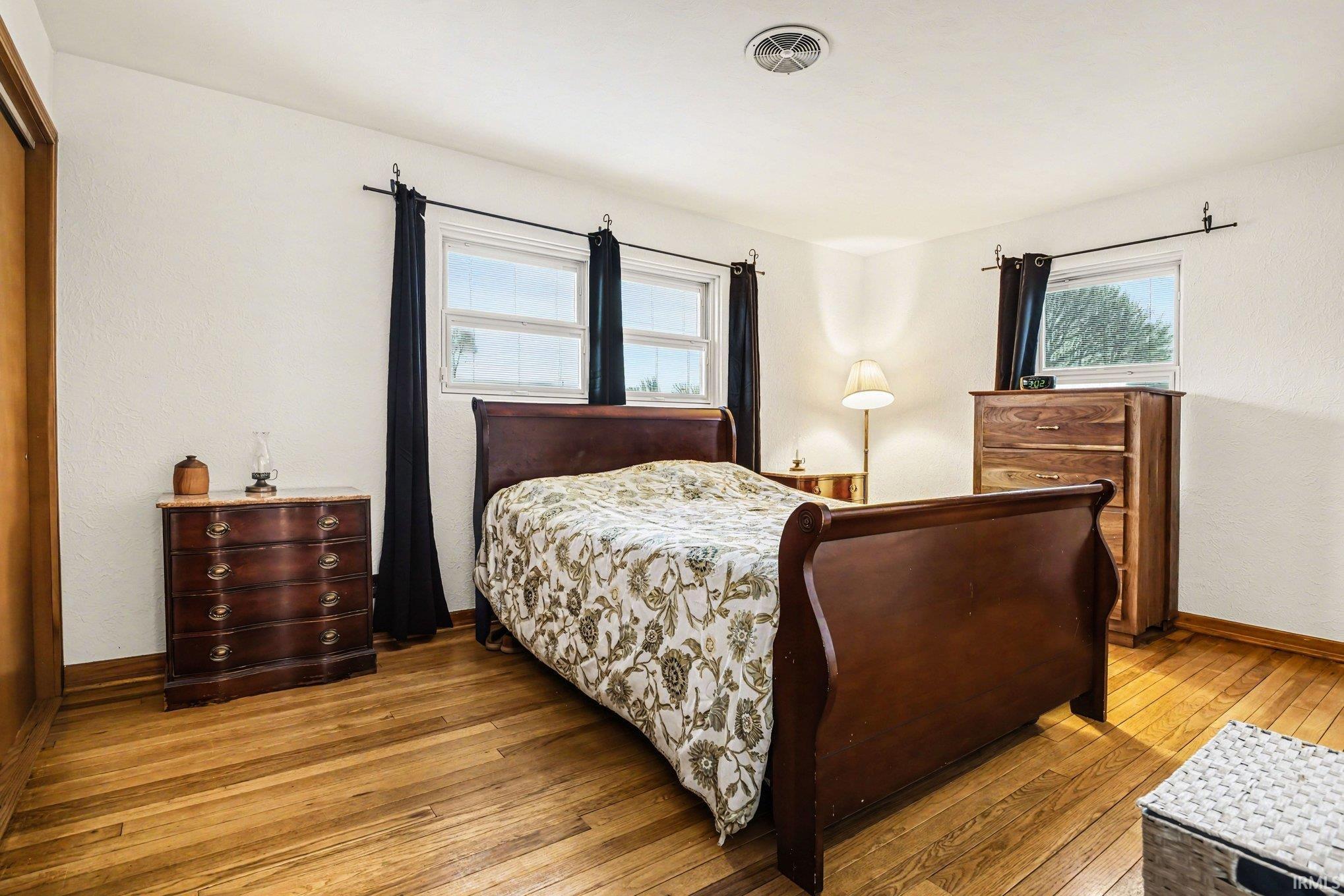 Bedroom featuring hardwood / wood-style floors and multiple windows