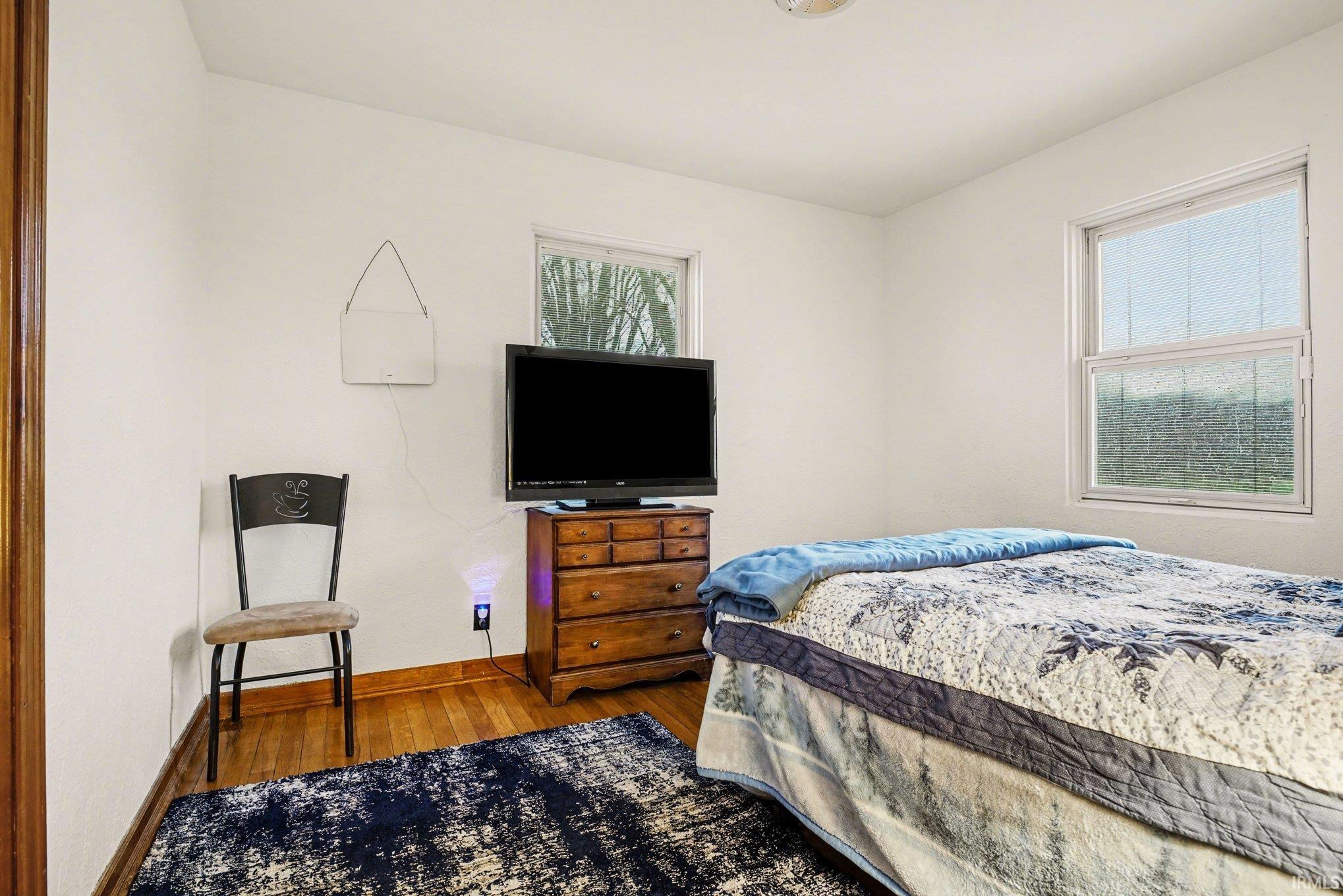Bedroom featuring wood finished floors and baseboards