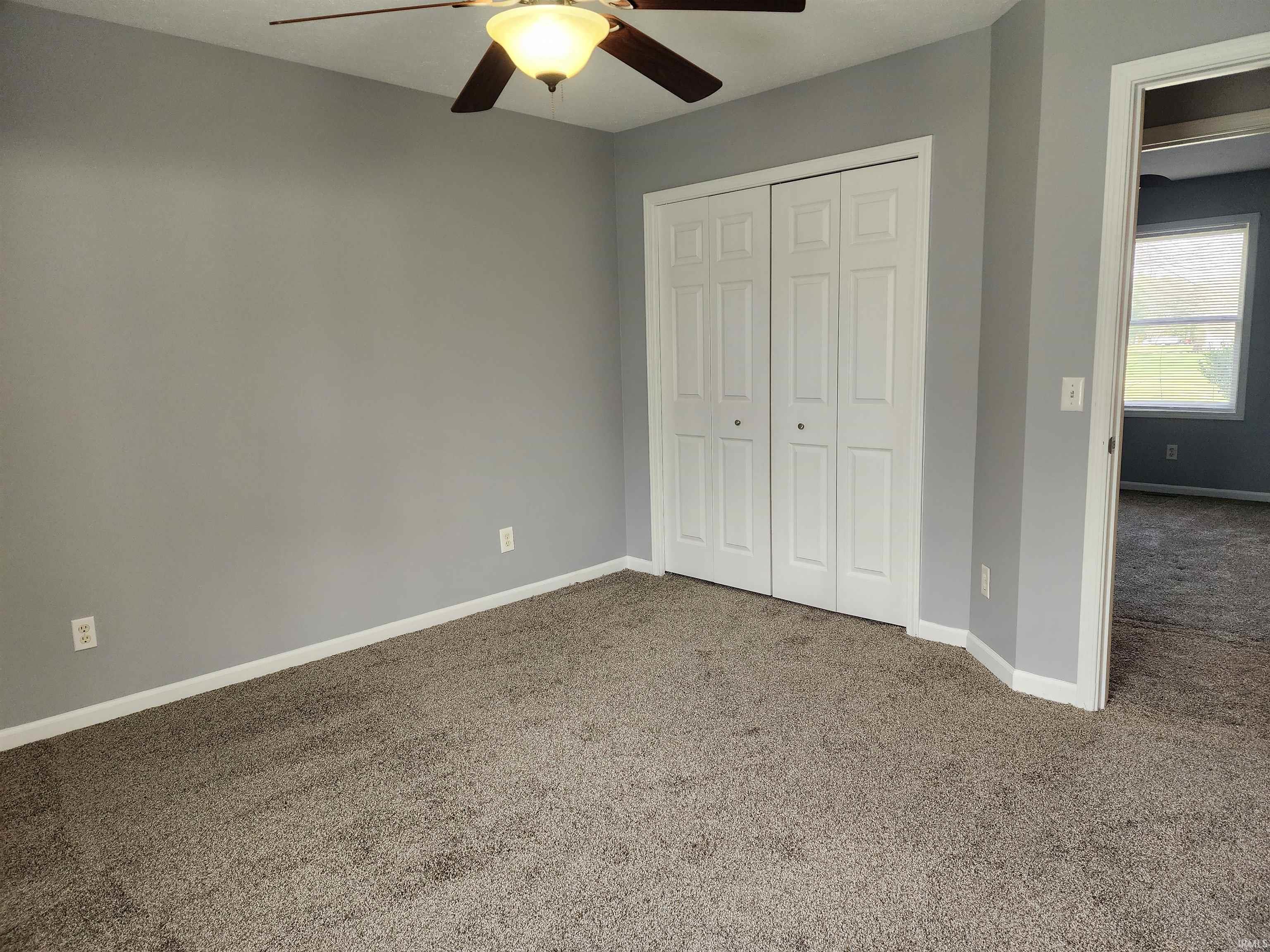 Unfurnished bedroom with carpet flooring, a closet, and ceiling fan