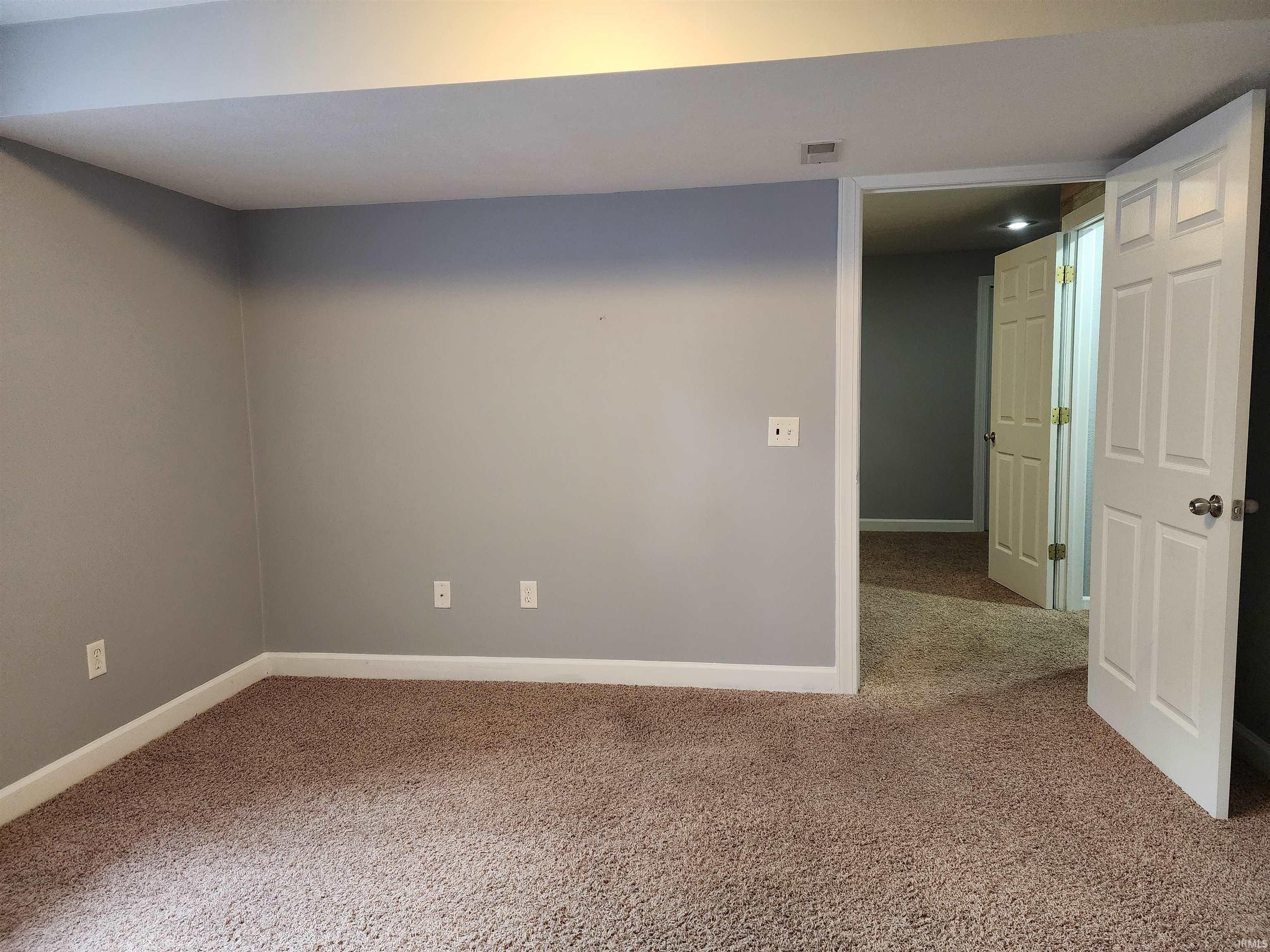 Unfurnished room featuring baseboards and carpet