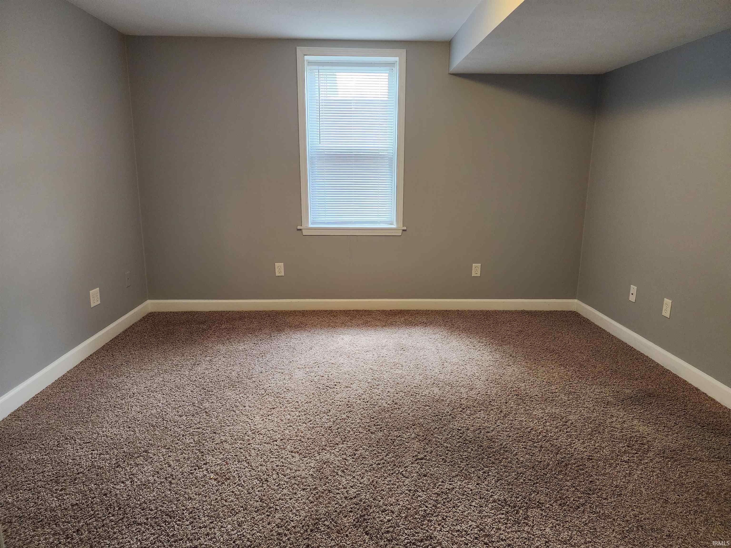 Carpeted spare room with baseboards