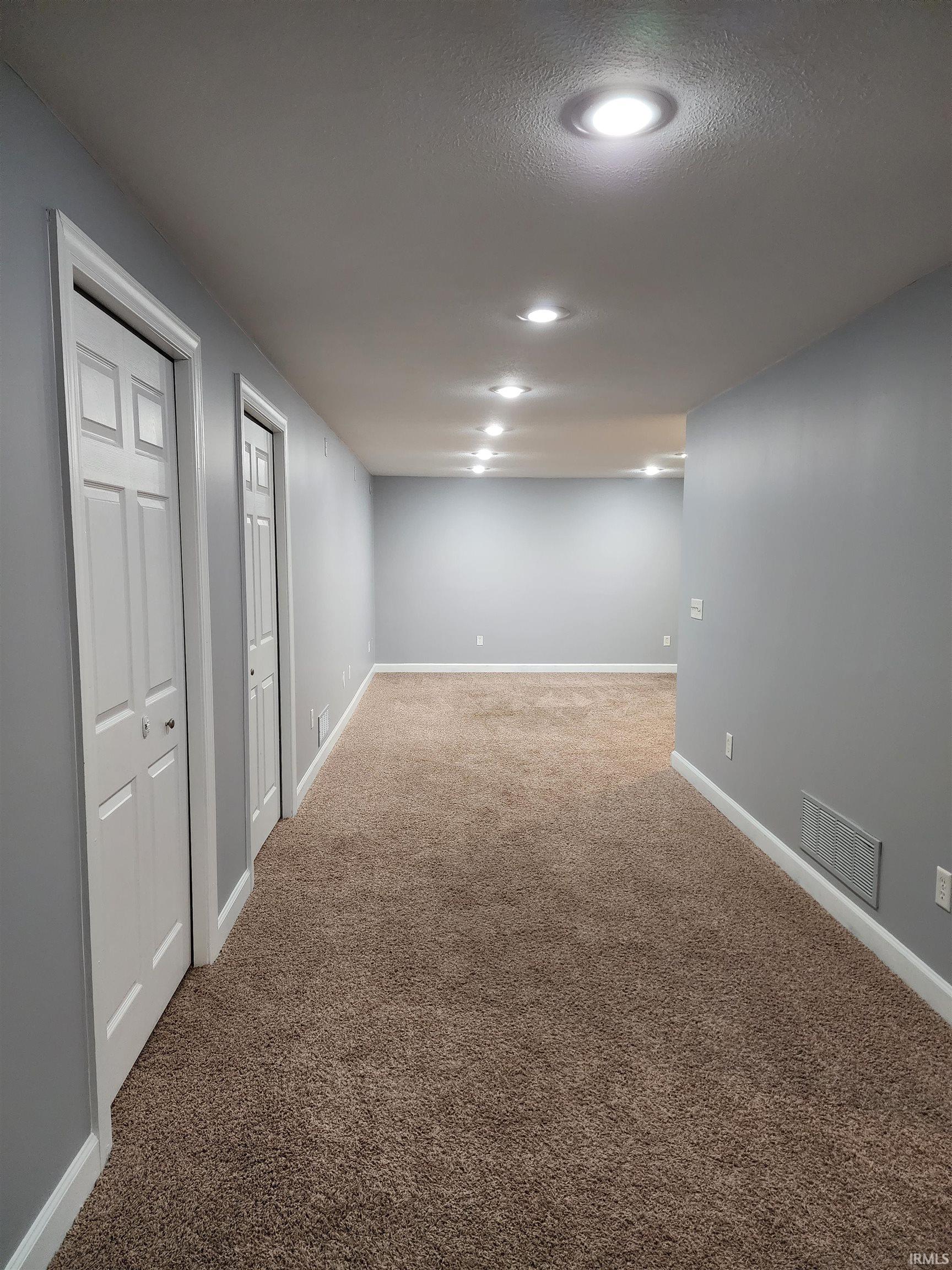 Finished below grade area featuring light carpet and recessed lighting