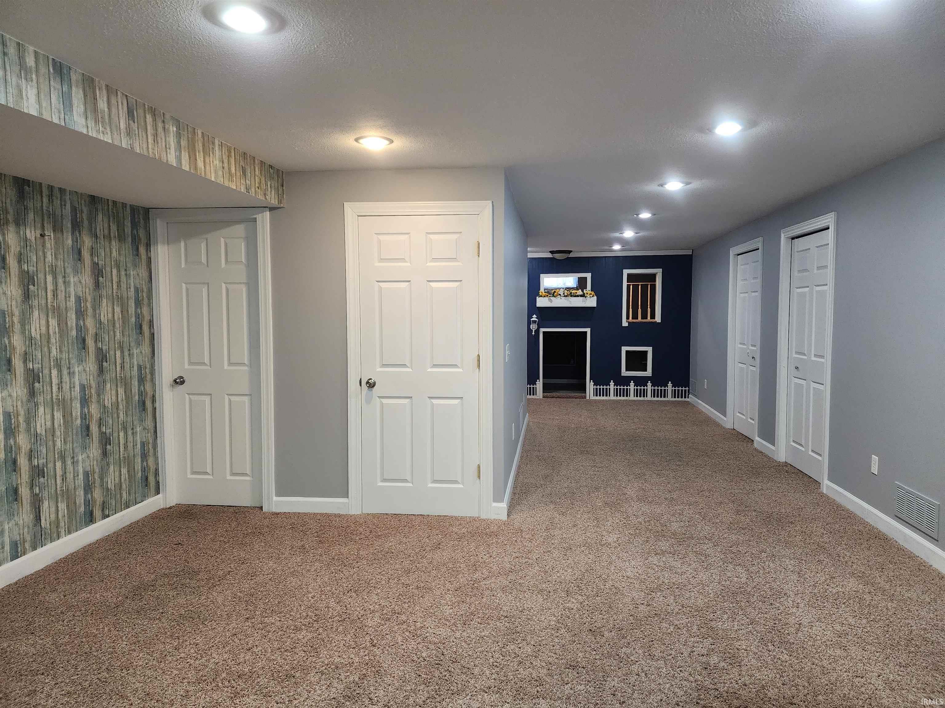 Finished basement with carpet floors, recessed lighting, and a textured ceiling