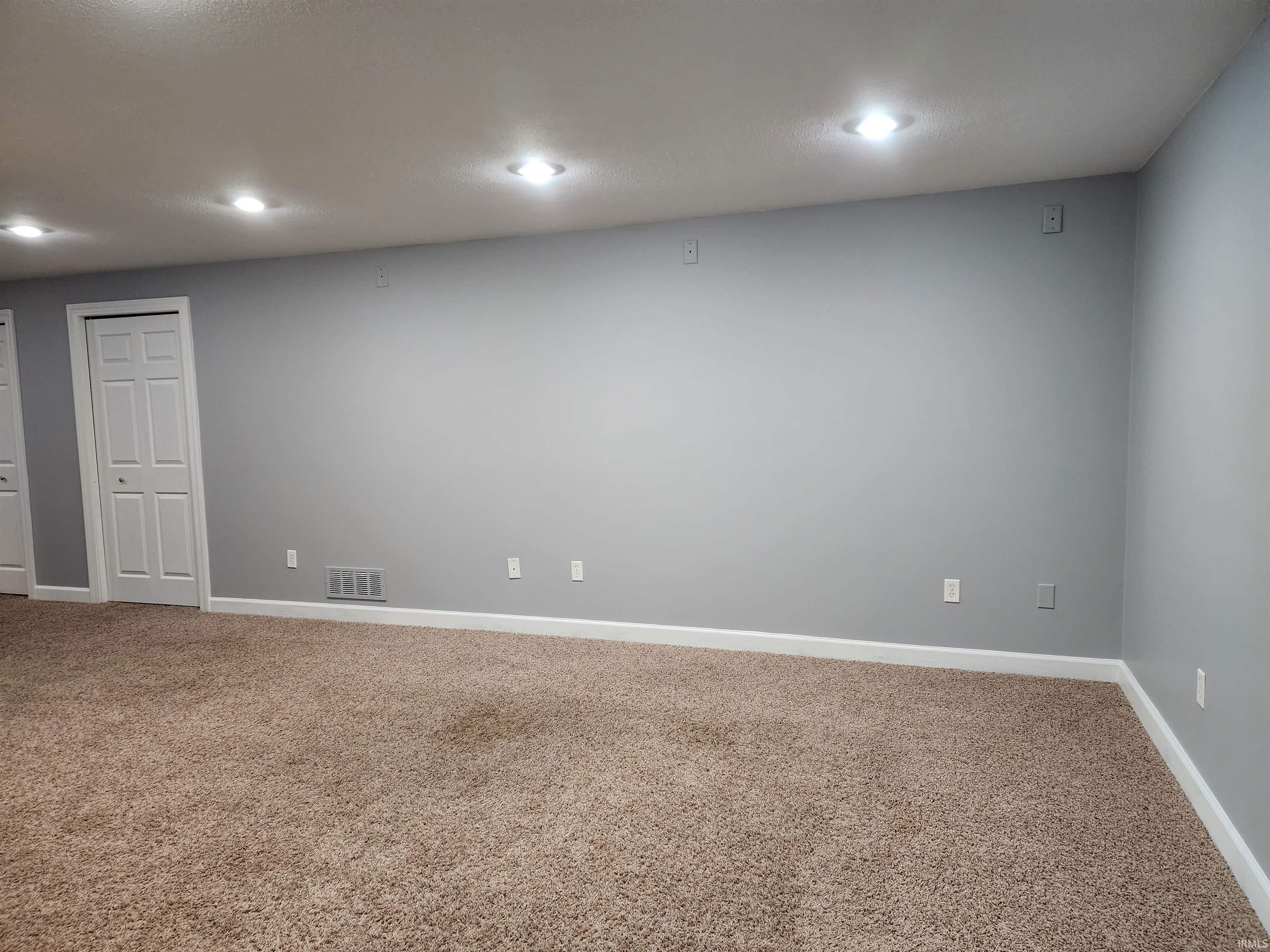 Carpeted spare room featuring baseboards and recessed lighting