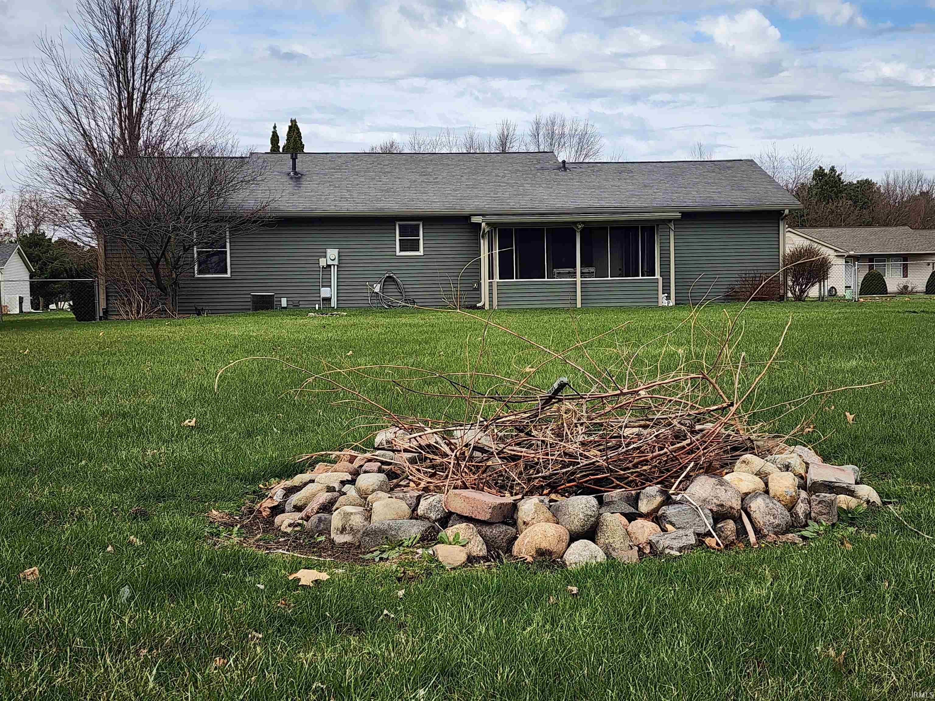 Rear view of property with a sunroom, a yard, and a shingled roof