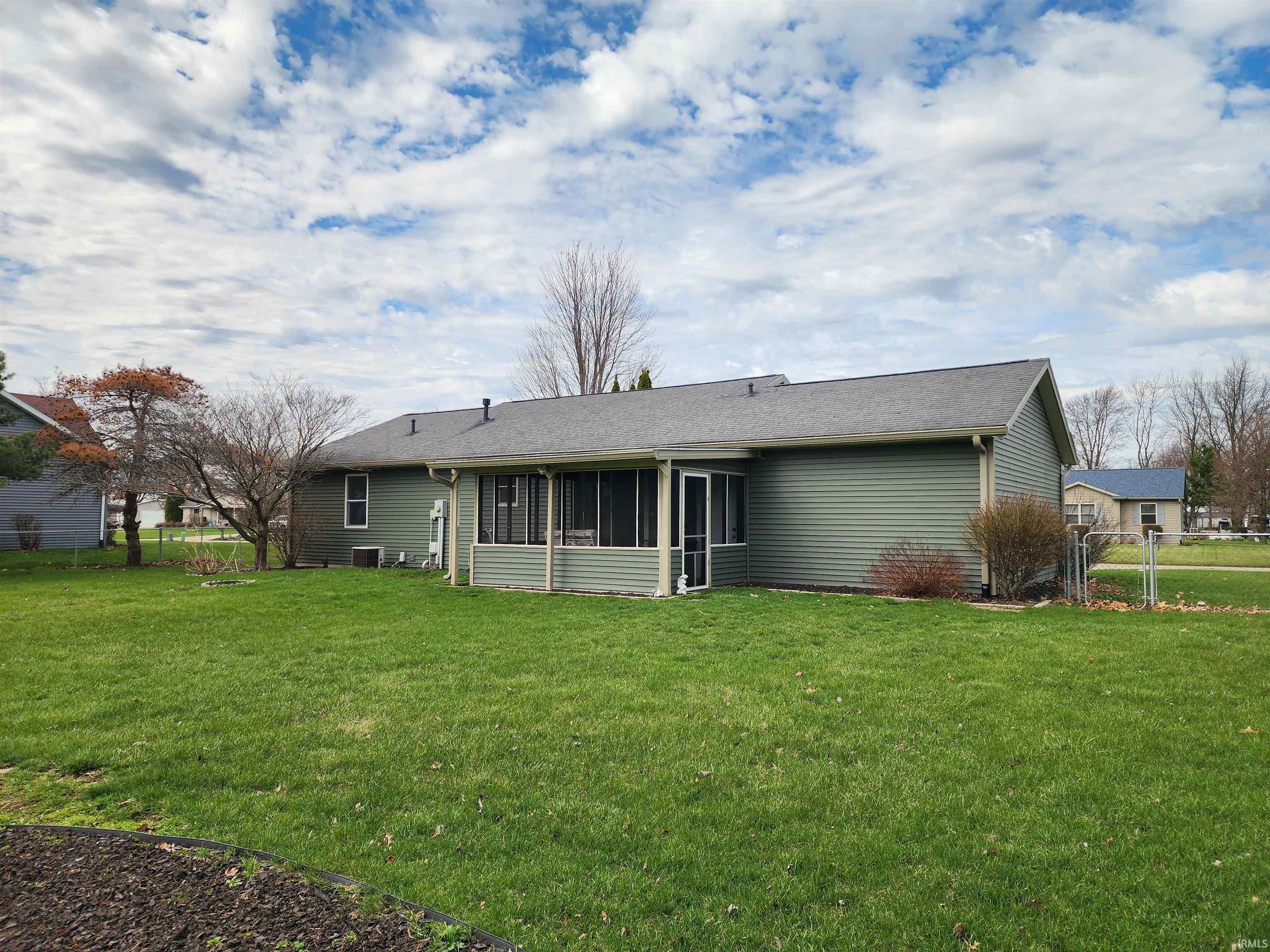 Rear view of house with a sunroom, a gate, and roof with shingles