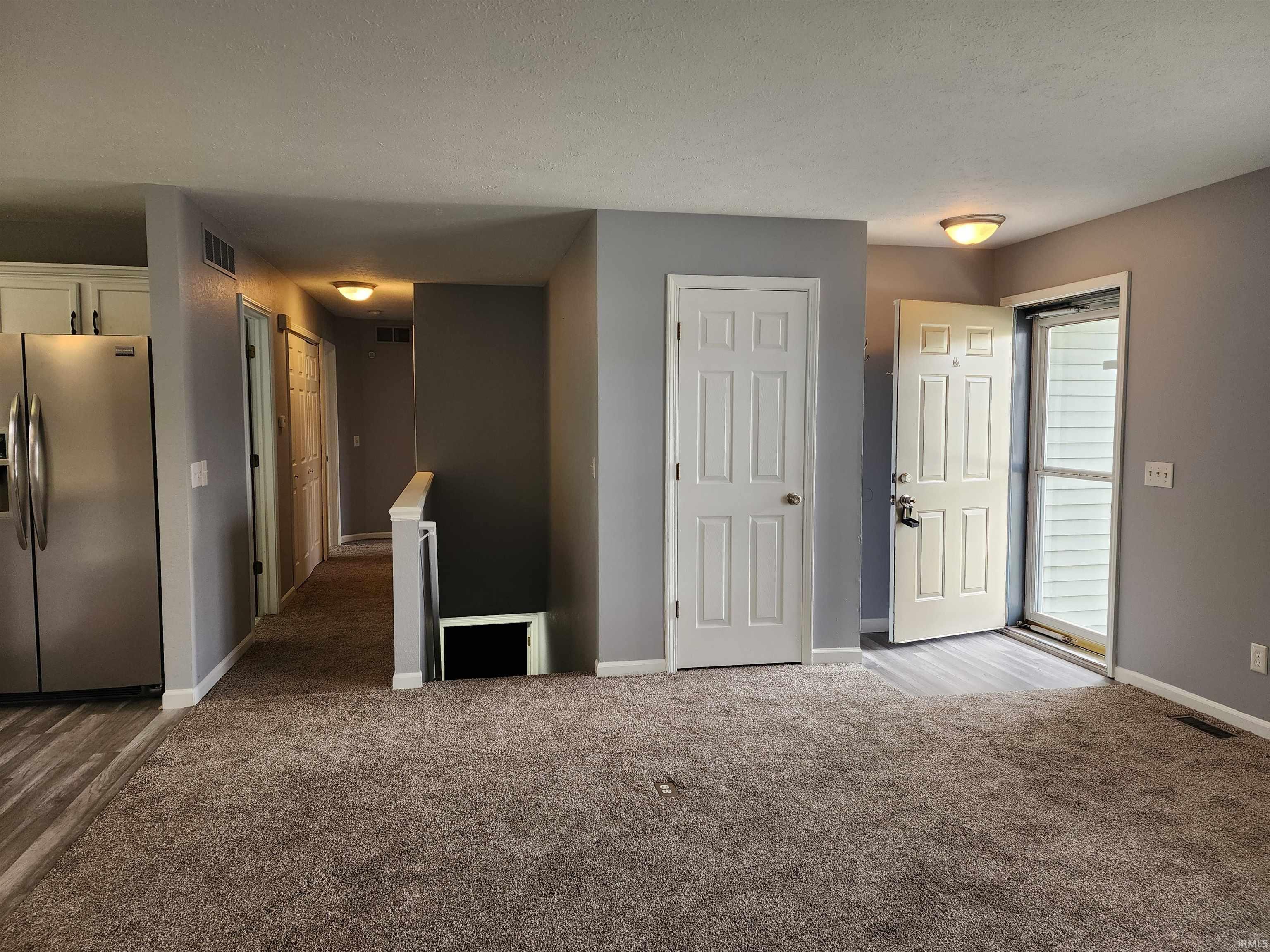 Unfurnished room featuring dark carpet