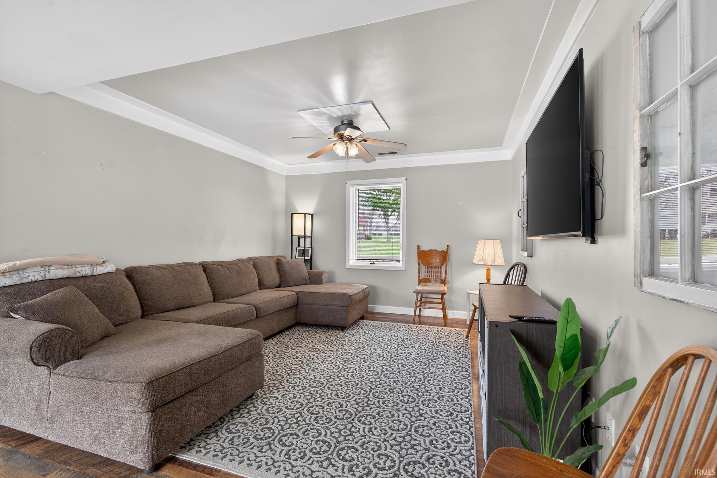 Living room with ceiling fan, crown molding, and wood finished floors
