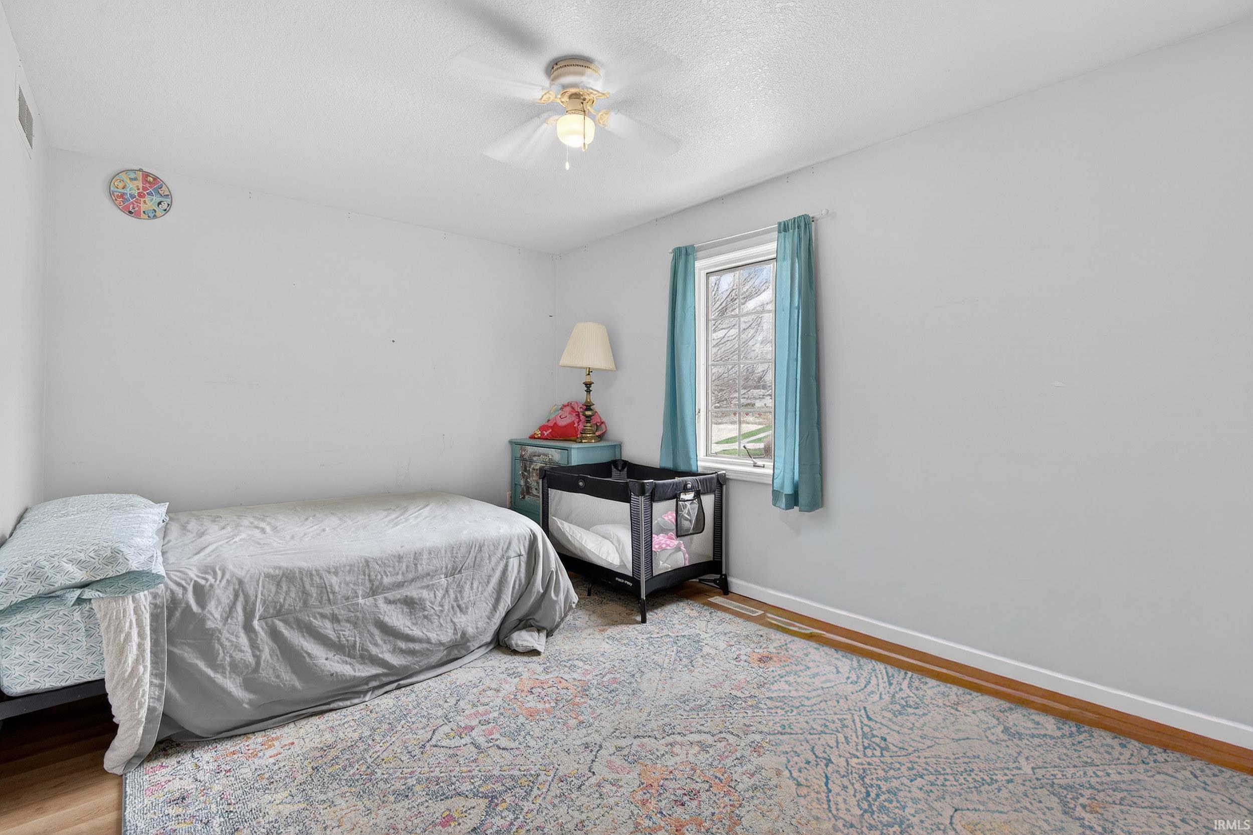 Bedroom featuring wood finished floors and a ceiling fan