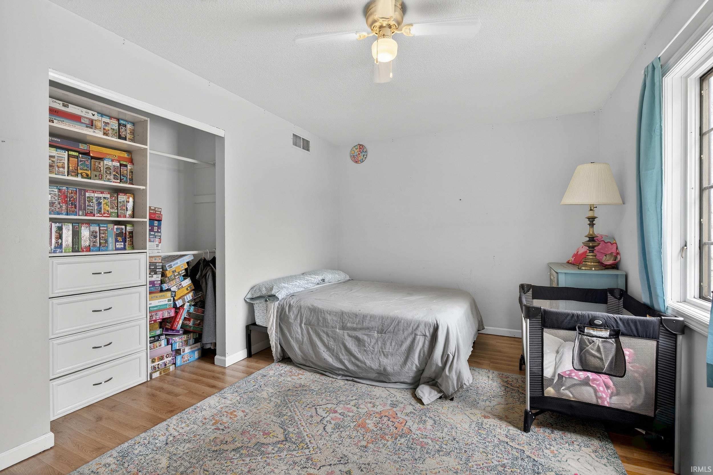 Bedroom with light wood-style floors, a closet, and ceiling fan