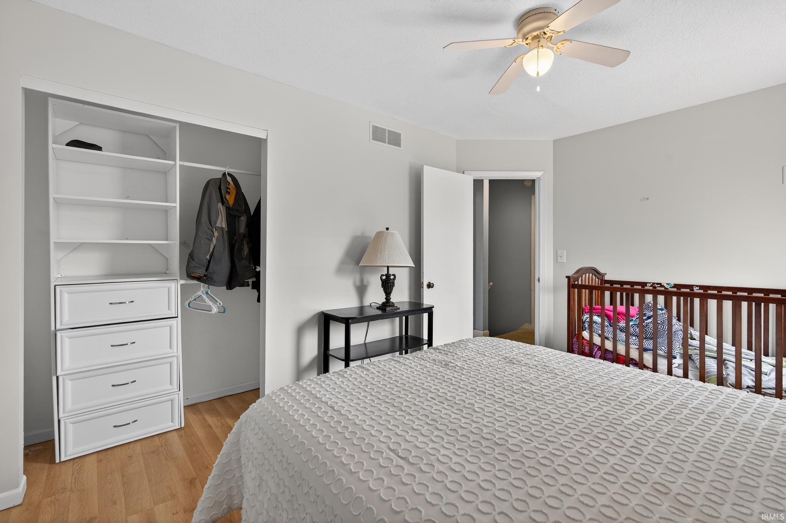 Bedroom with a closet, light wood-type flooring, and a ceiling fan