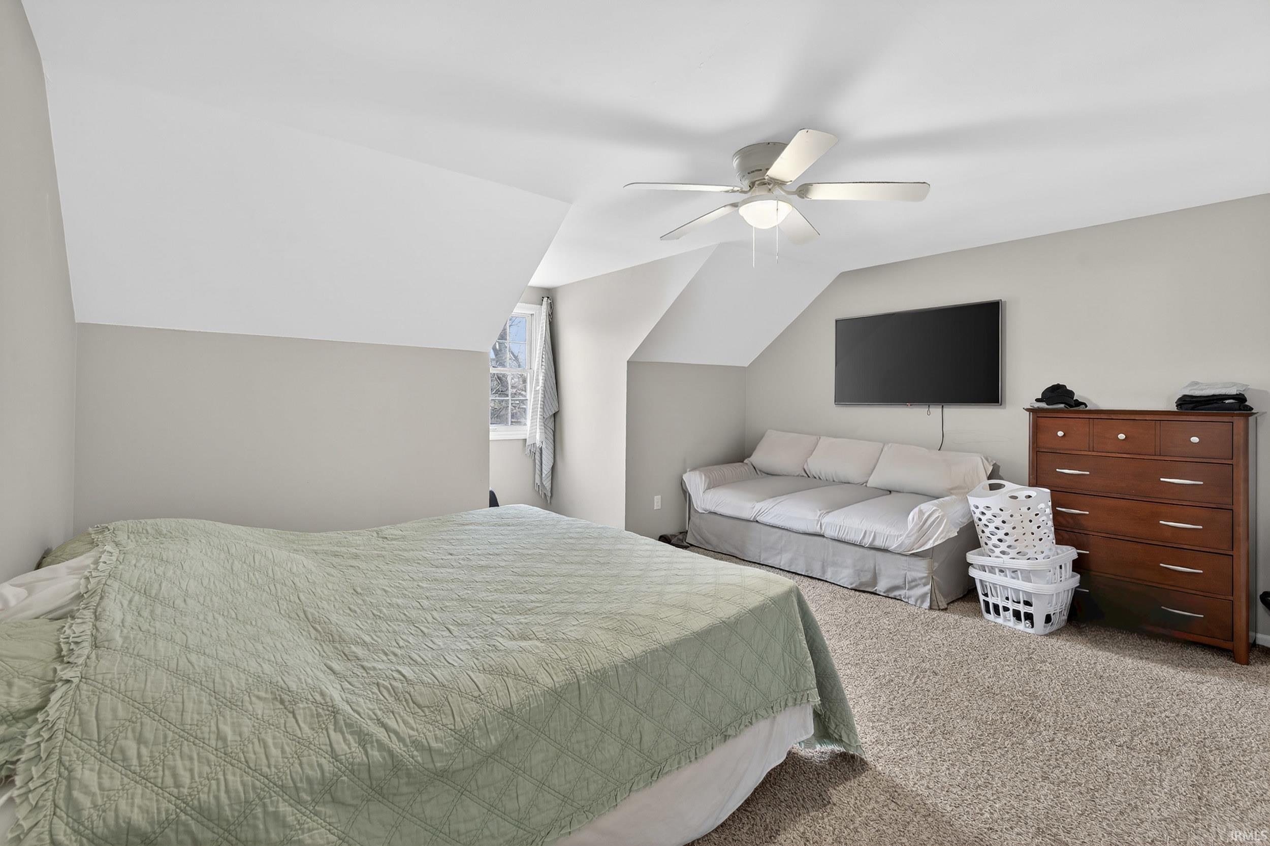 Bedroom featuring vaulted ceiling, carpet floors, and ceiling fan