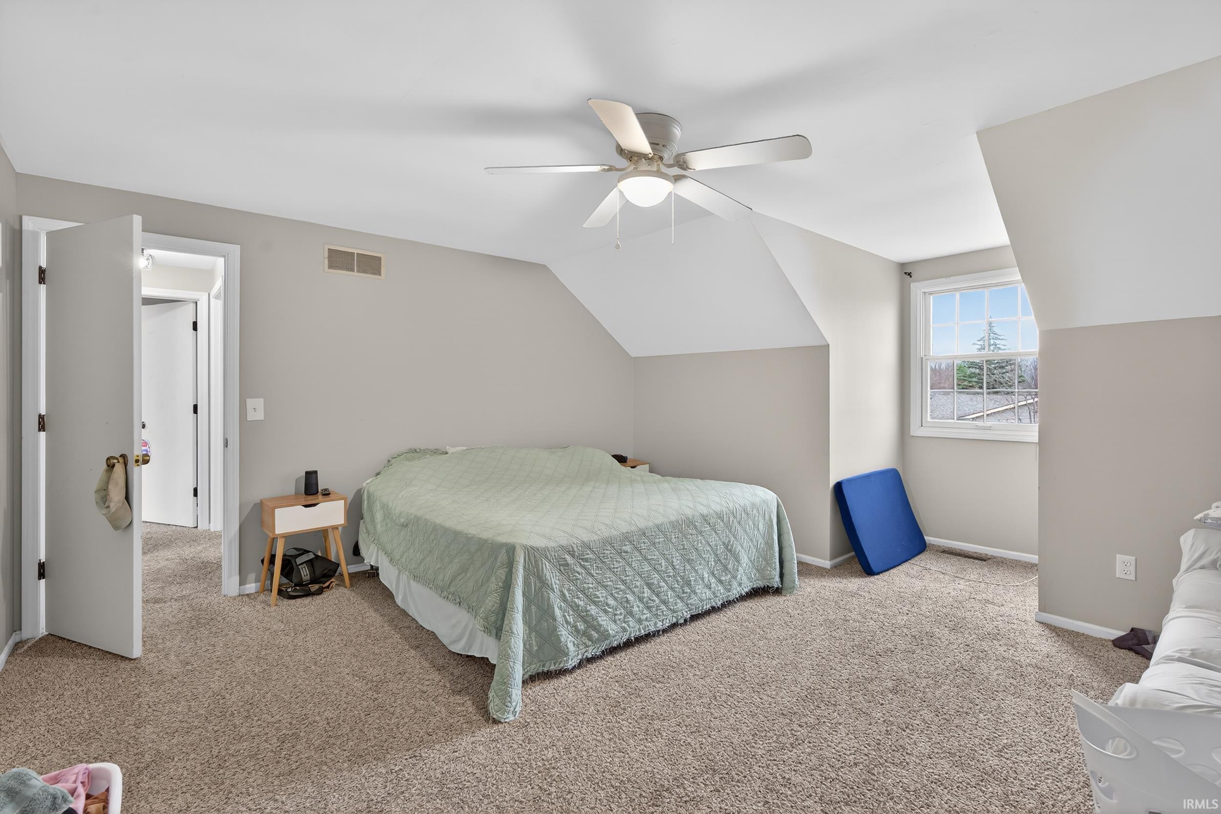 Bedroom featuring lofted ceiling, a ceiling fan, and light colored carpet