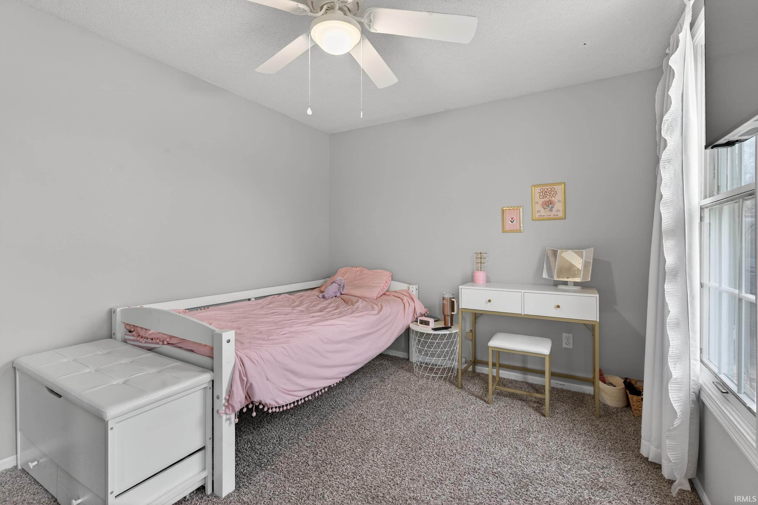Carpeted bedroom featuring a ceiling fan and baseboards