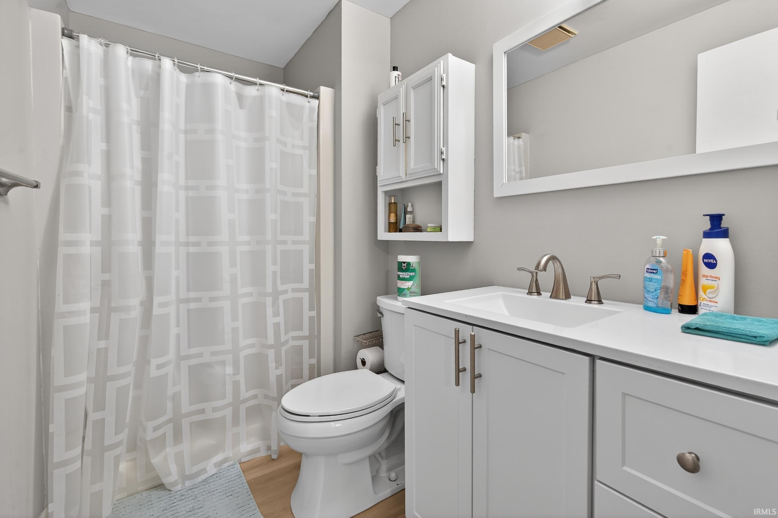Bathroom featuring vanity, a shower with shower curtain, and light wood finished floors