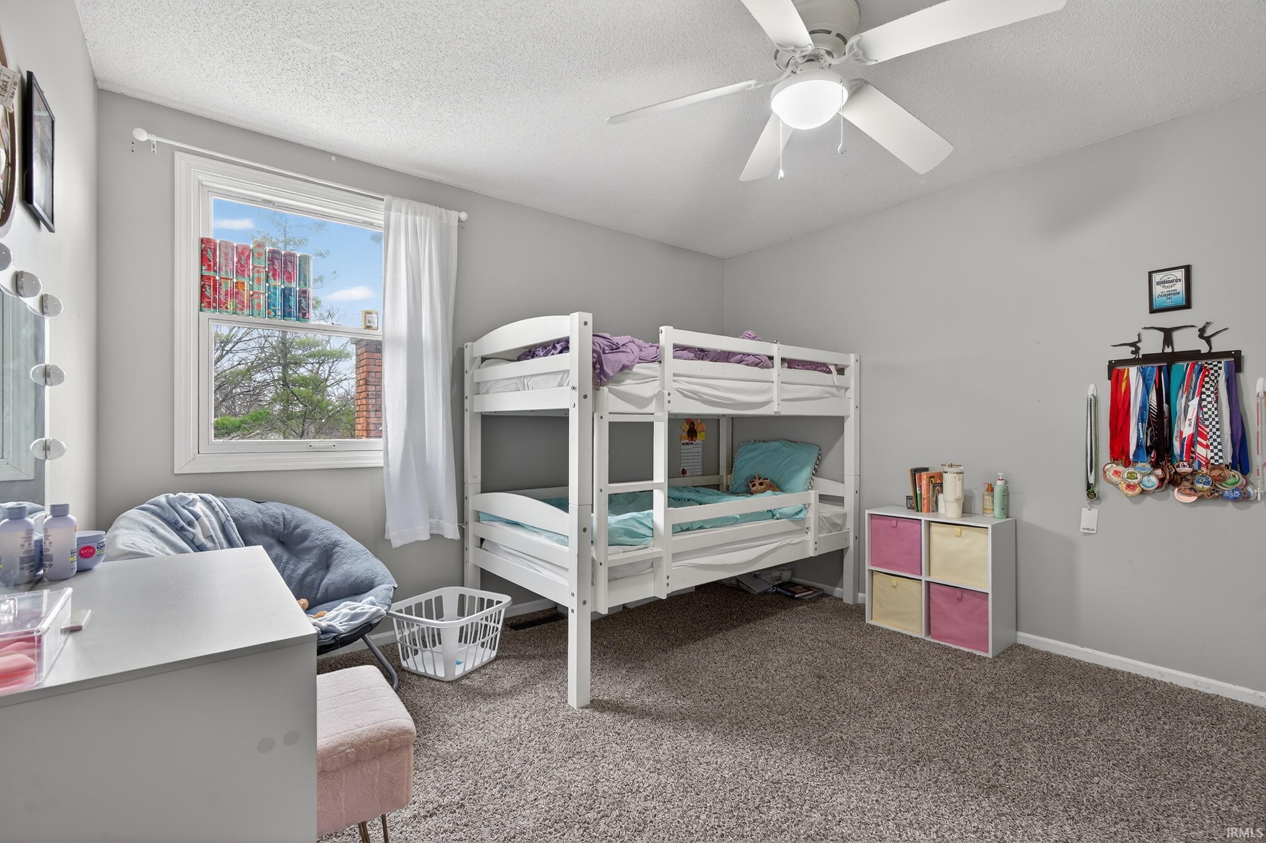 Carpeted bedroom featuring a textured ceiling and a ceiling fan