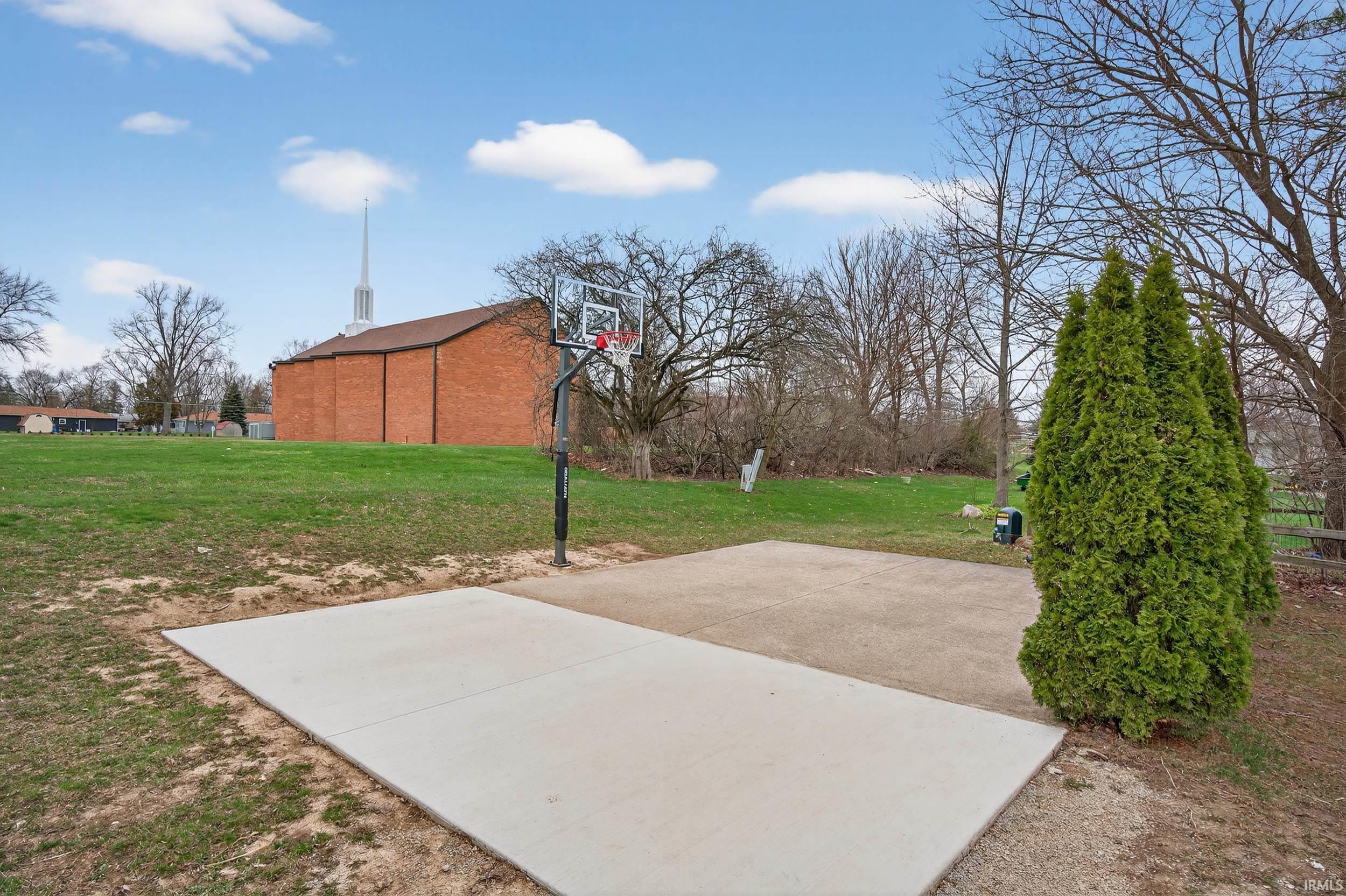 View of sport court featuring a lawn