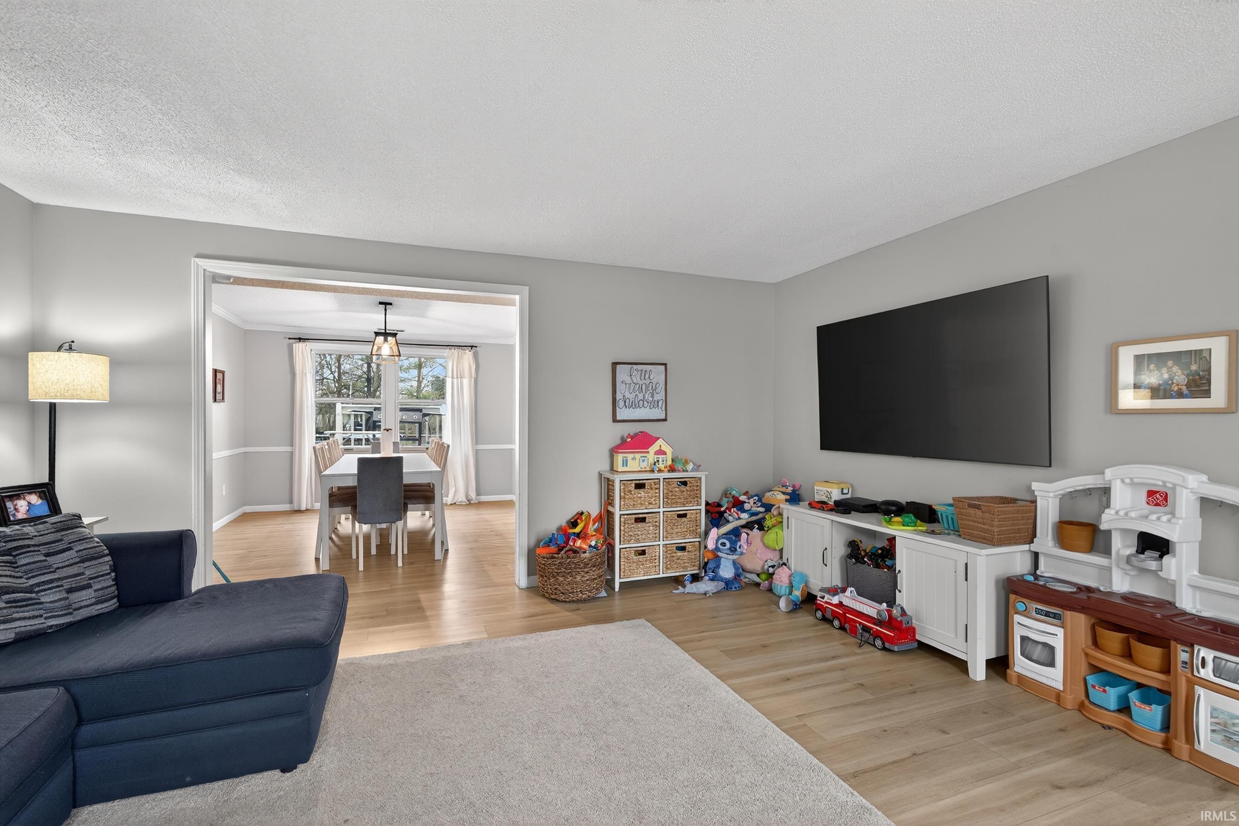 Living room featuring light wood-style flooring and a textured ceiling