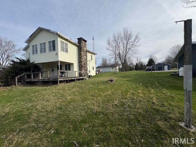 View of grassy yard with a wooden deck