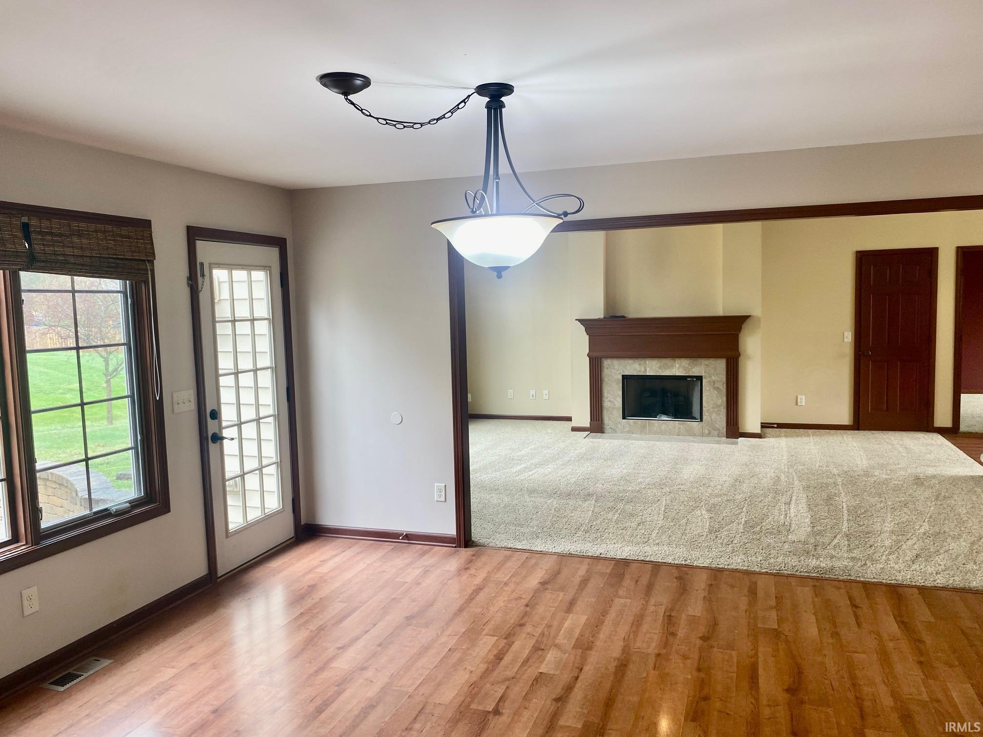 Unfurnished living room with a premium fireplace and light wood-type flooring