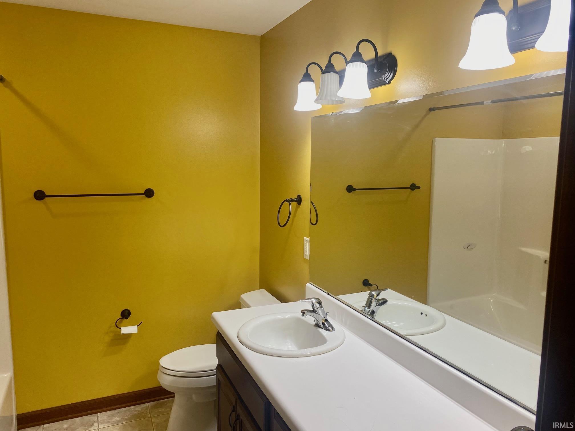 Bathroom with vanity, light tile patterned floors, and tub / shower combination