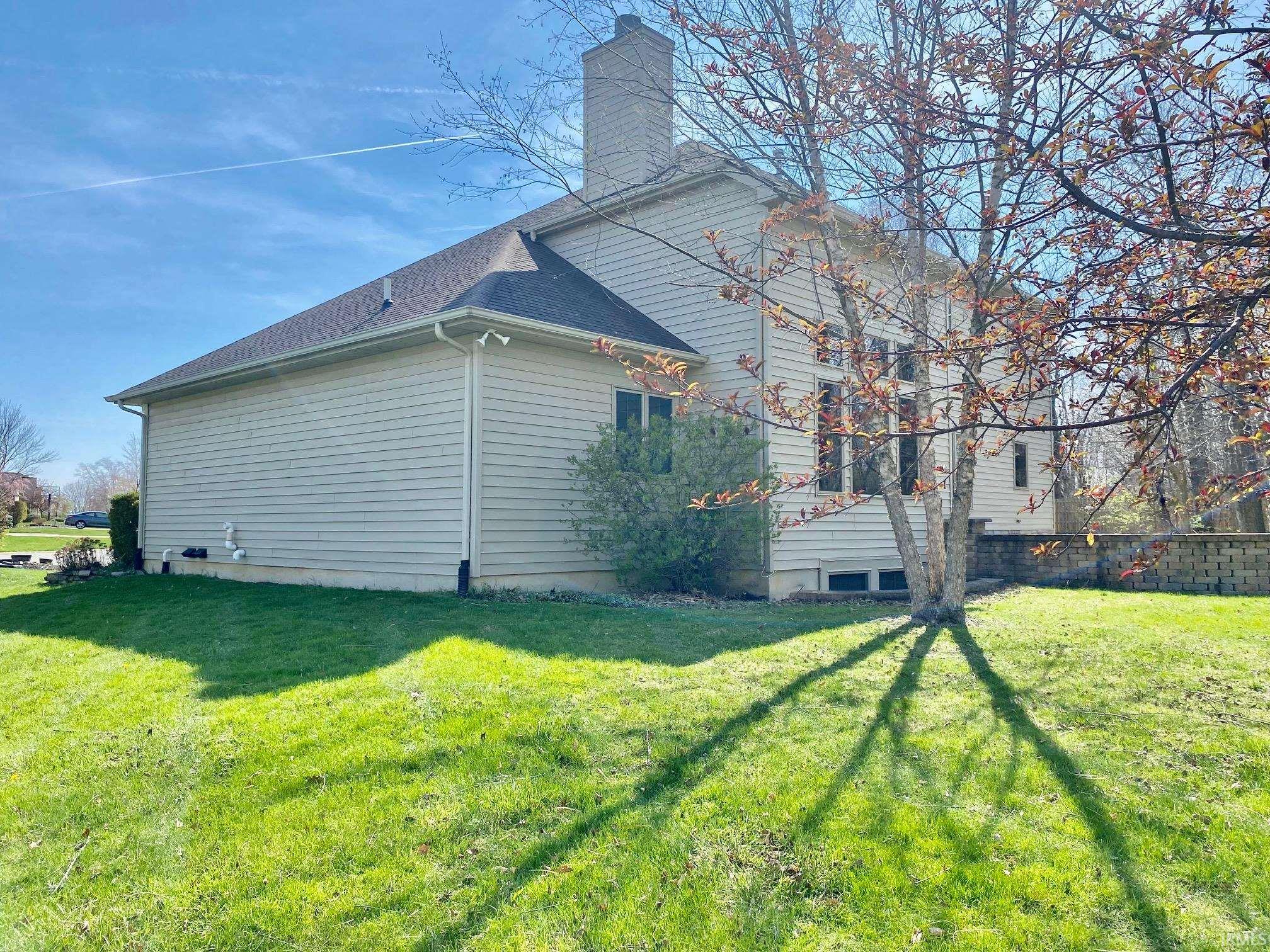 View of property exterior with a chimney and a shingled roof