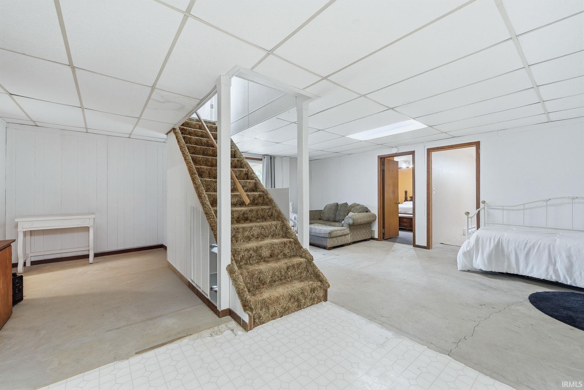 Finished below grade area with a drop ceiling and wood walls