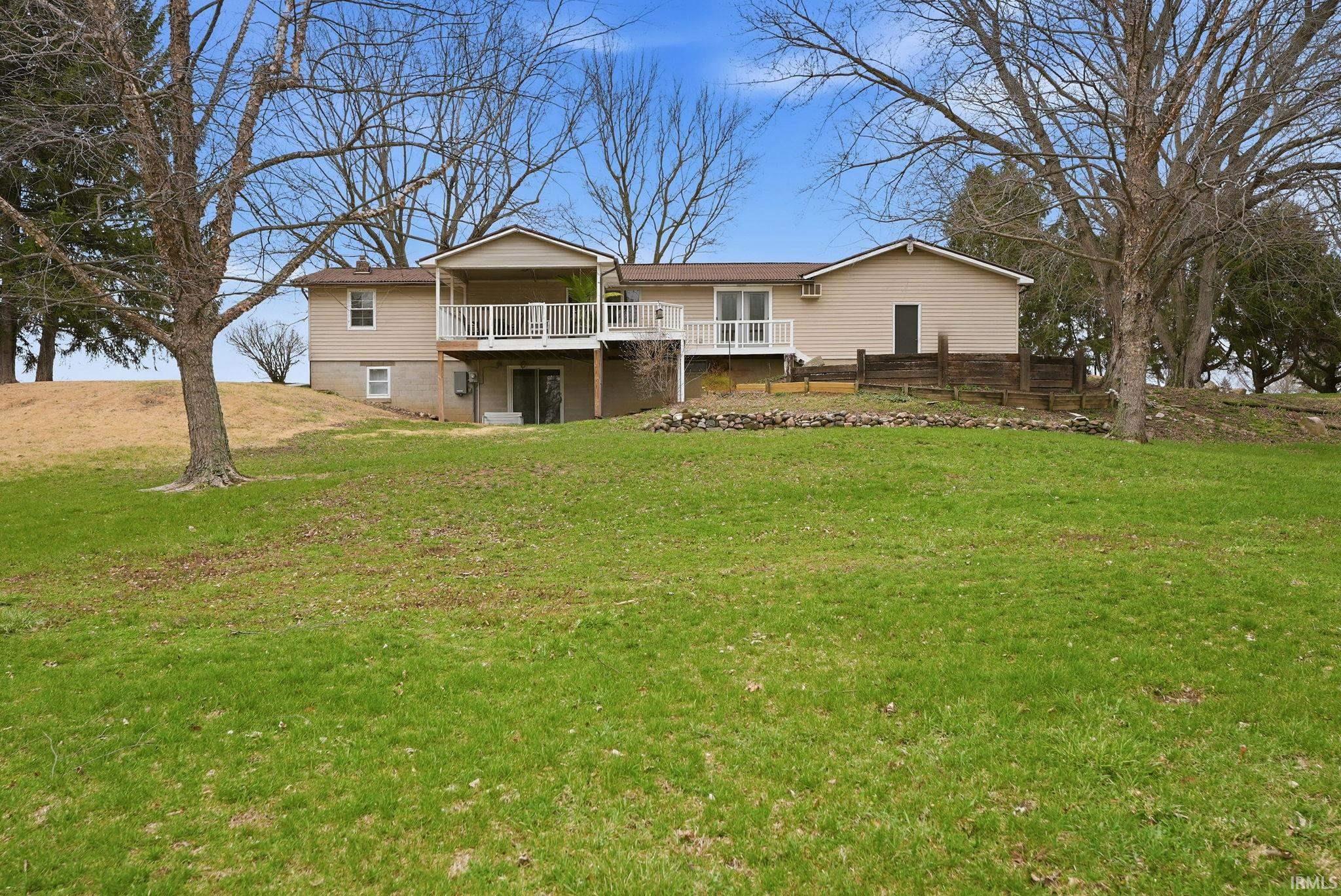 Rear view of house featuring a yard and a deck
