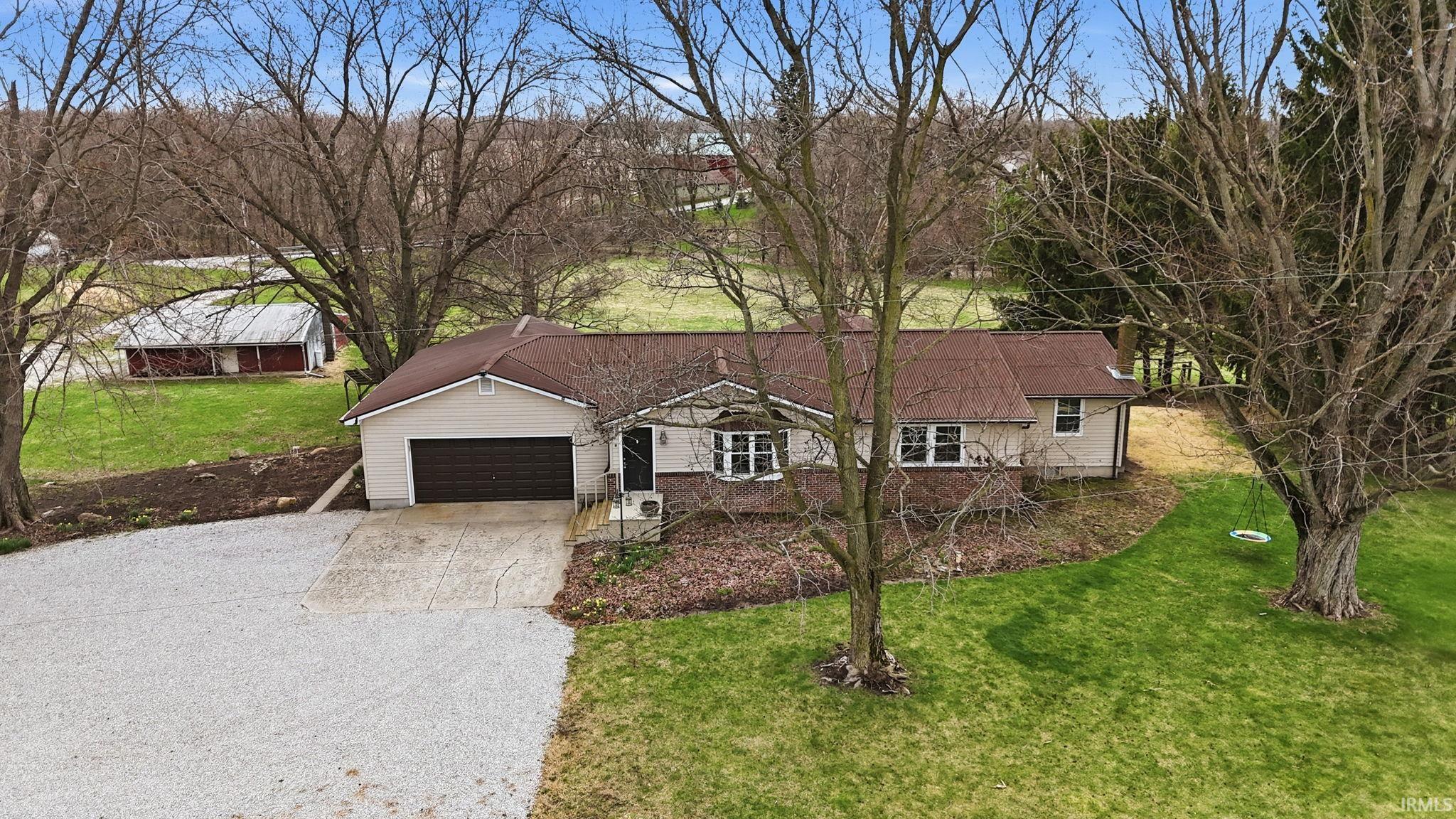 Single story home featuring a front lawn, driveway, and an attached garage