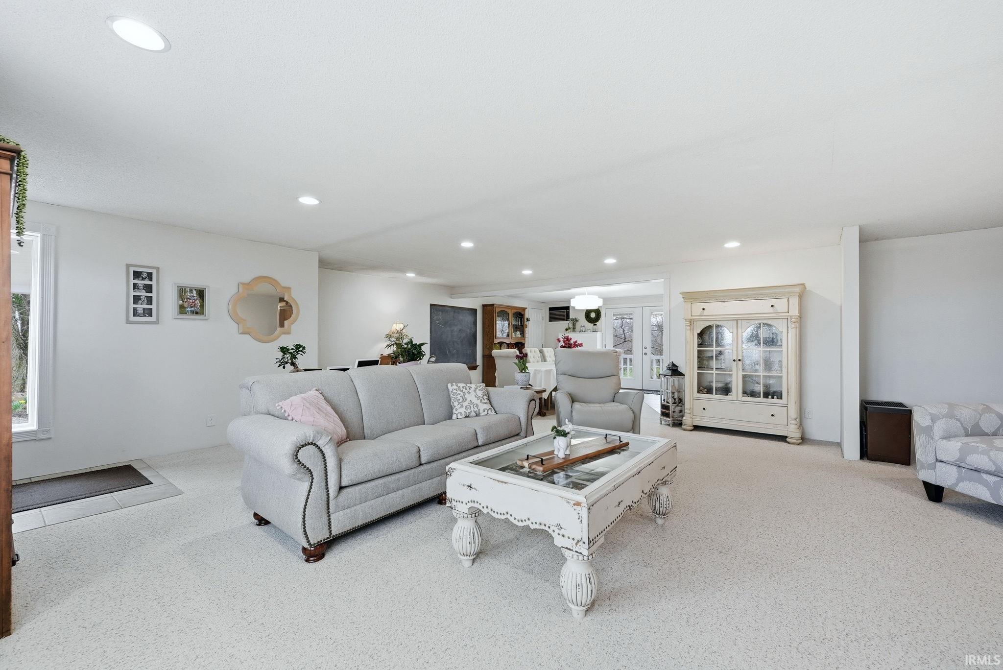 Living room featuring light colored carpet and recessed lighting