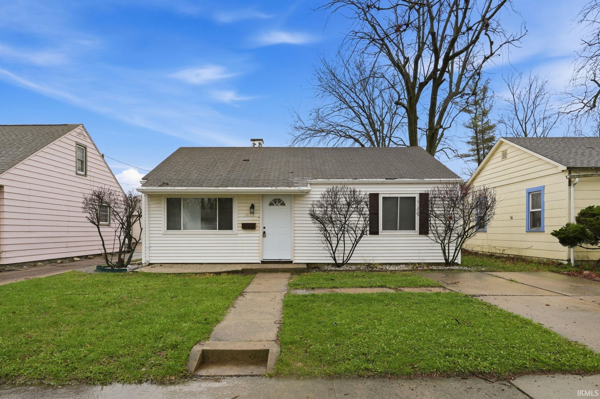 View of front of property with a front lawn and roof with shingles