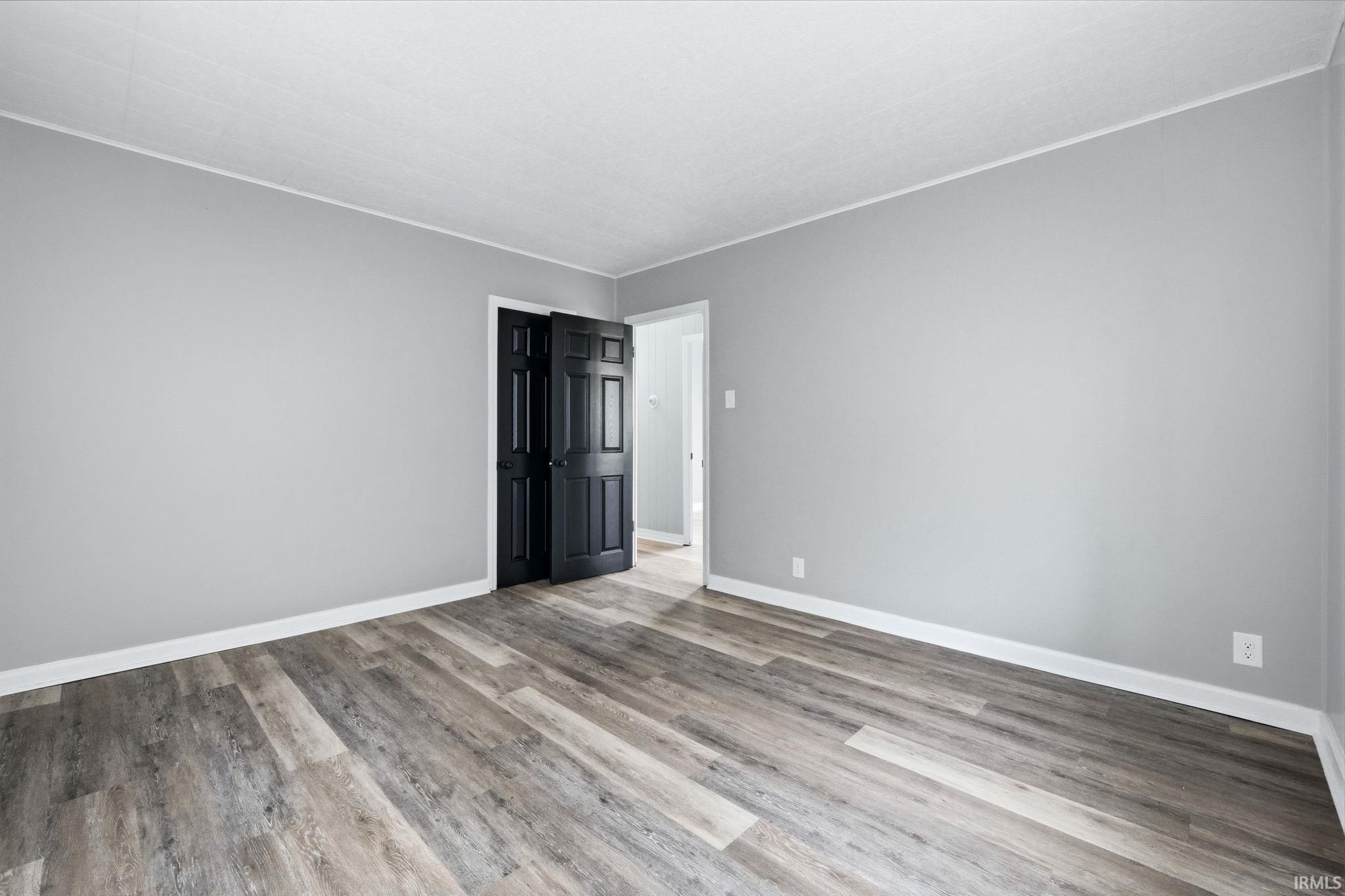 Empty room featuring crown molding and light wood-style floors