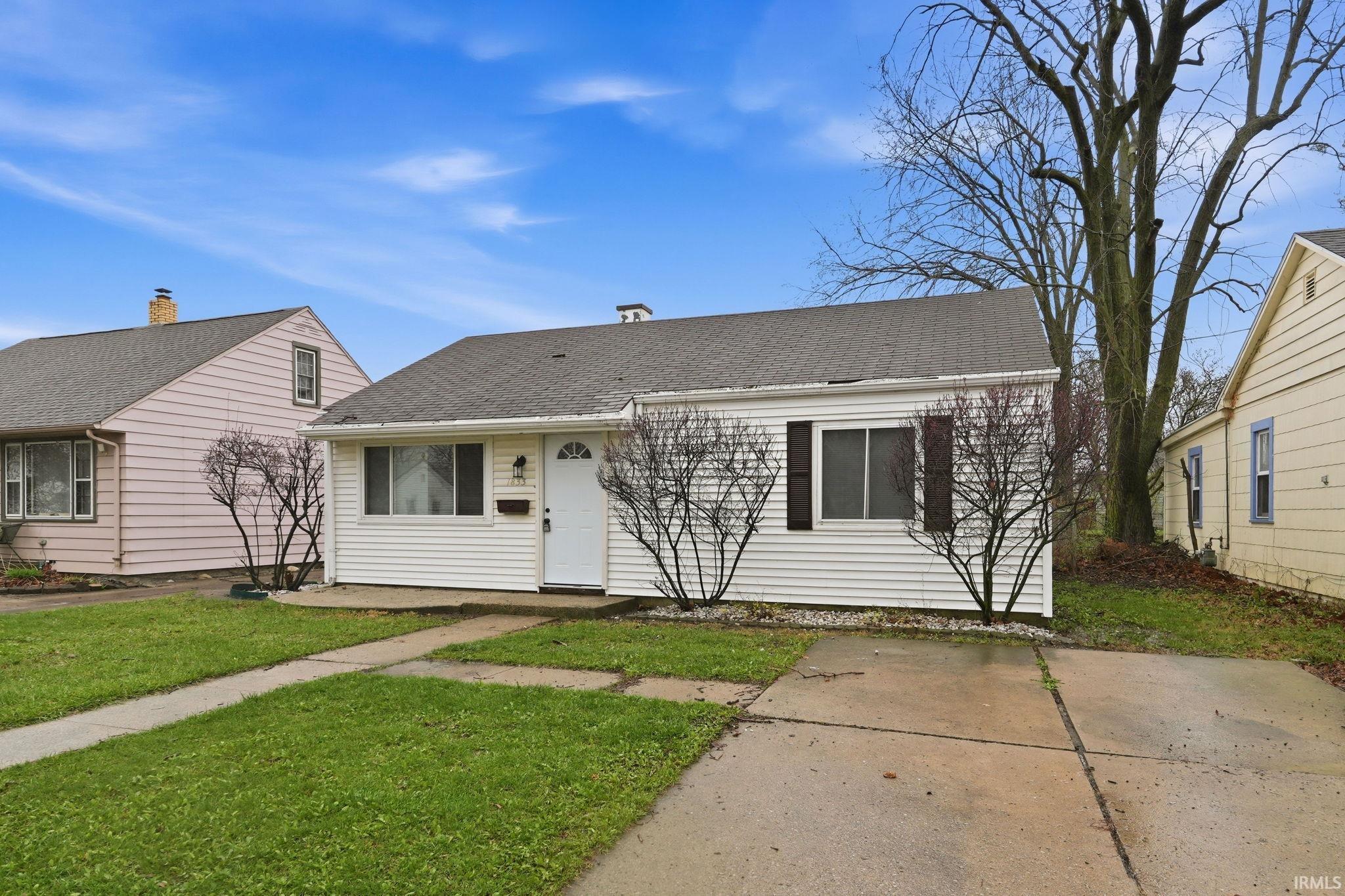 View of front of property with a shingled roof and a front yard