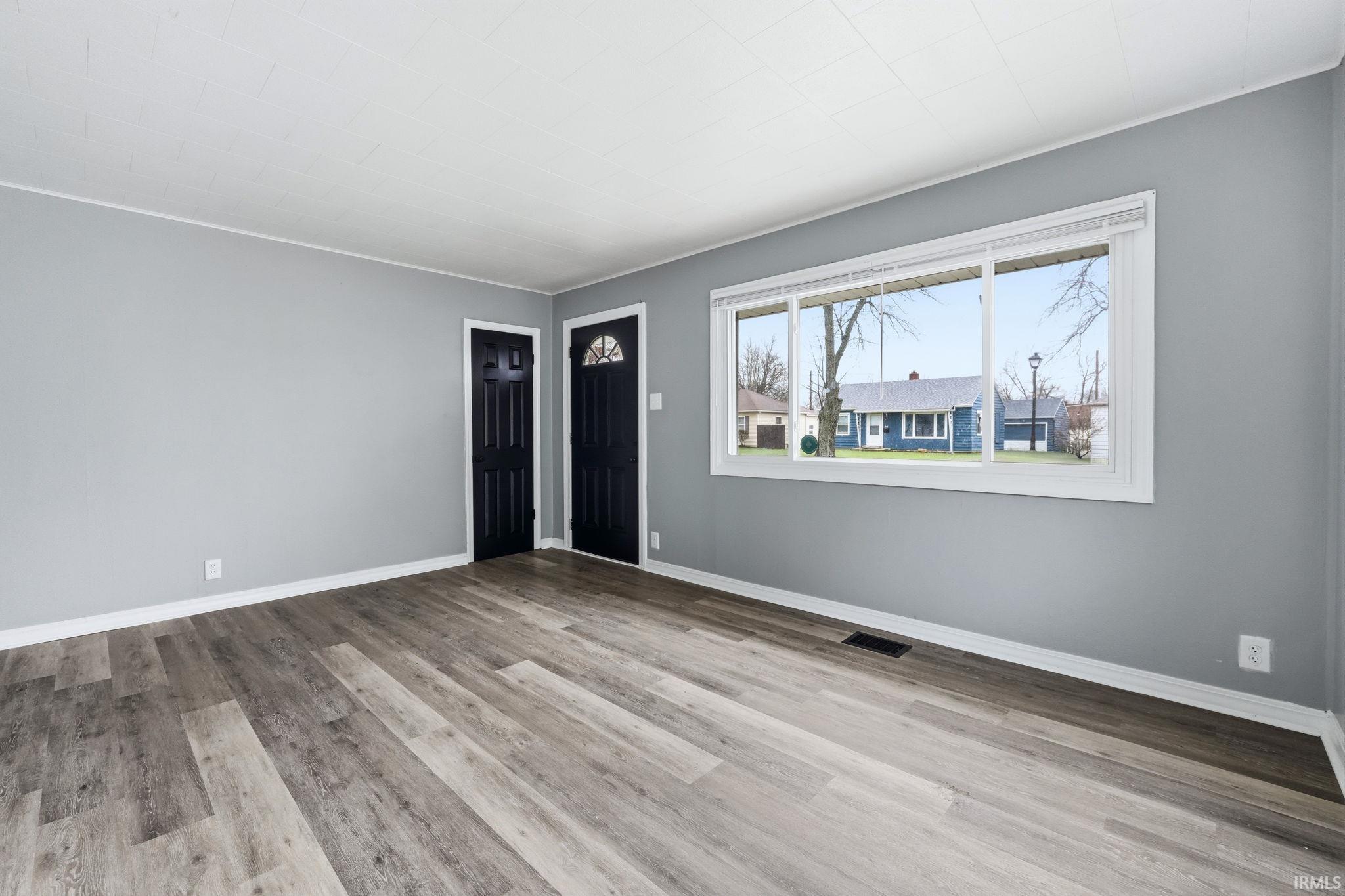 Unfurnished living room featuring light wood-type flooring and crown molding