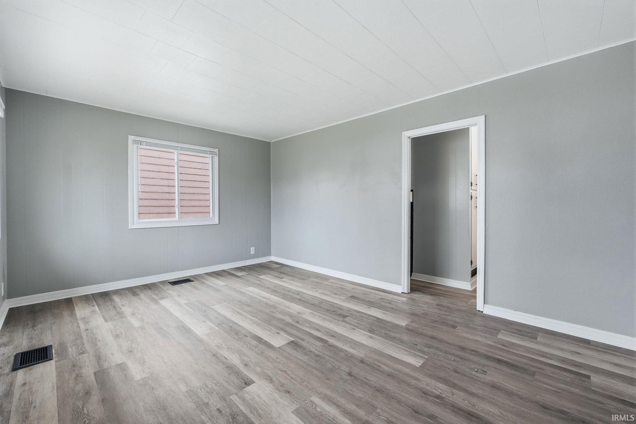 Unfurnished room with light wood-style flooring and baseboards