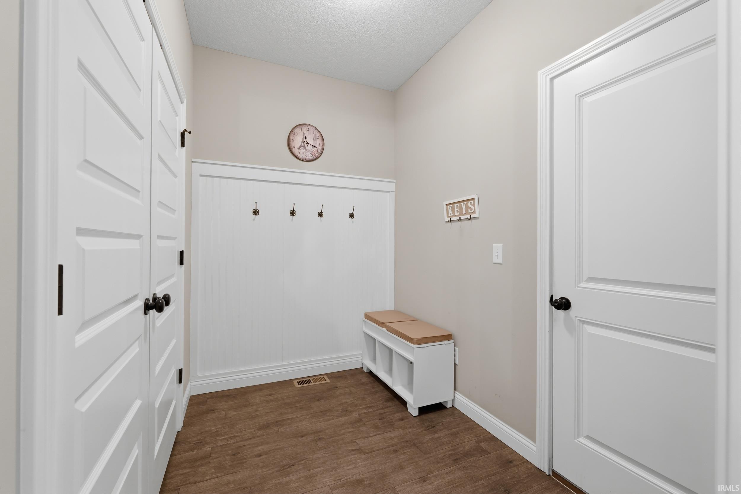 Mudroom featuring dark wood-type flooring and a textured ceiling
