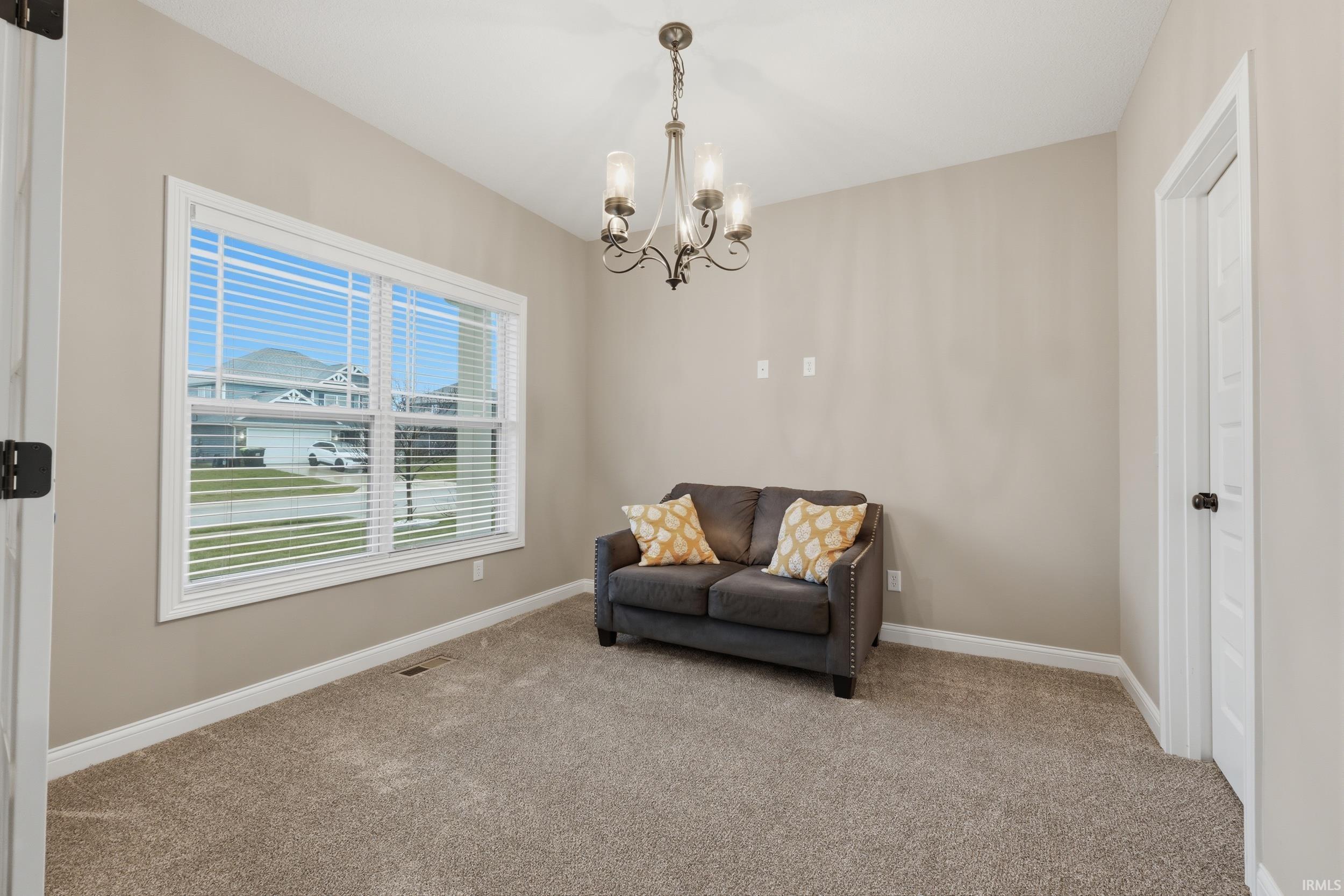 Living area featuring carpet and suspended lighting