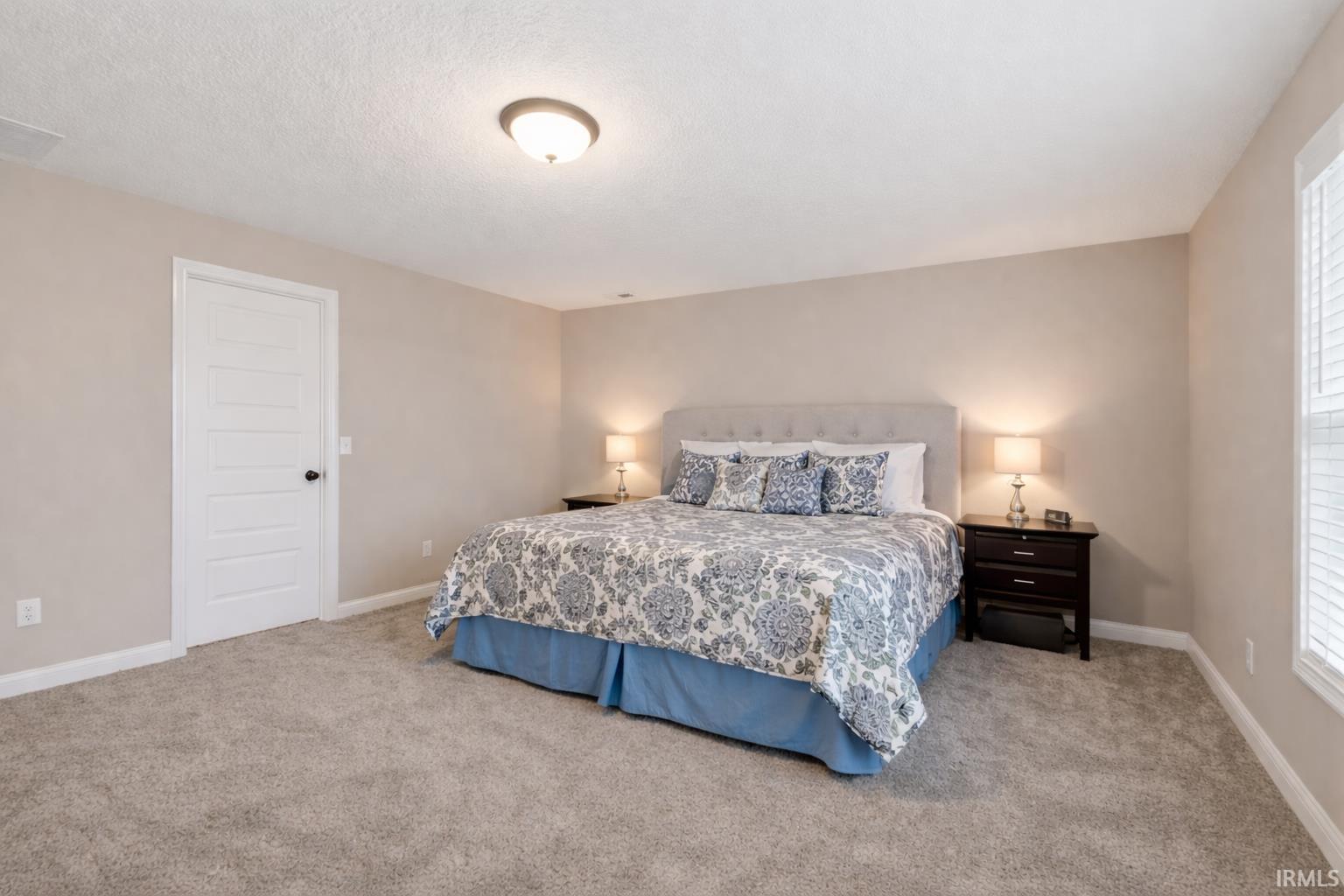 Bedroom featuring light colored carpet