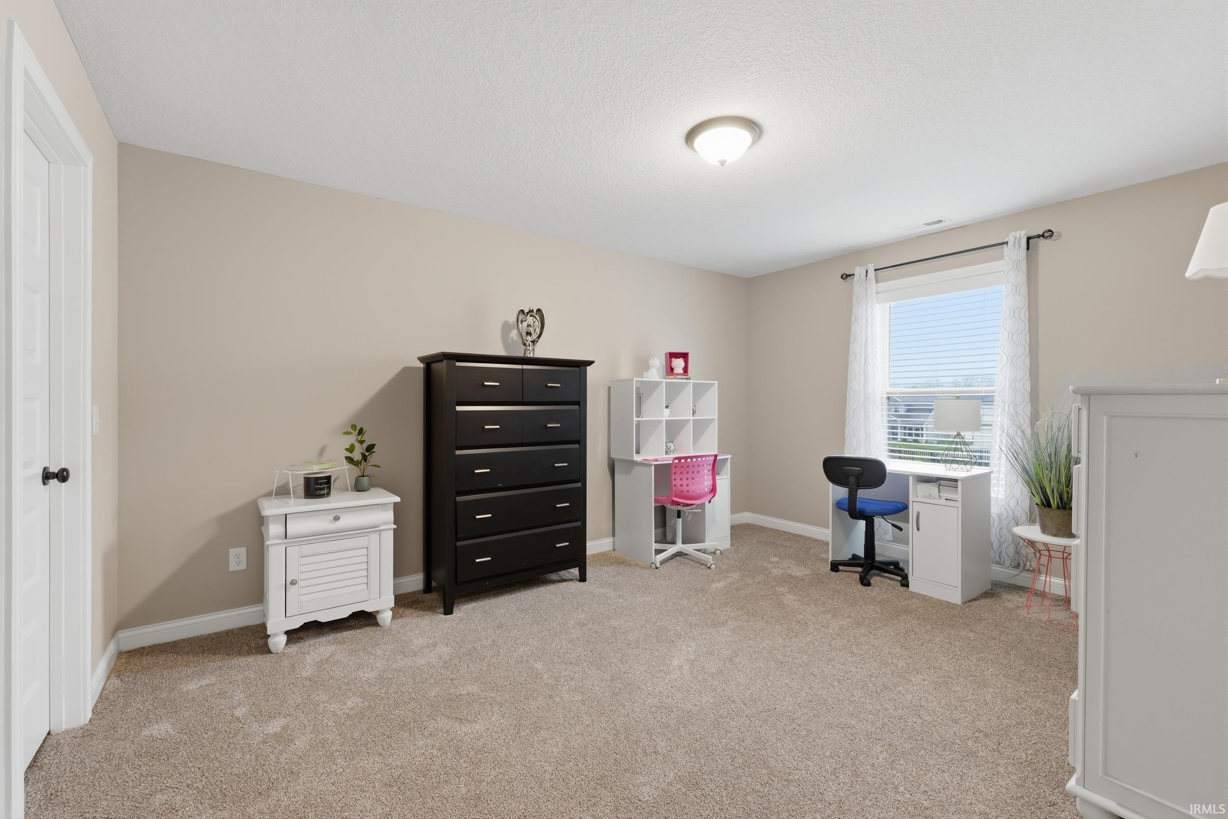 Office area with baseboards and light carpet