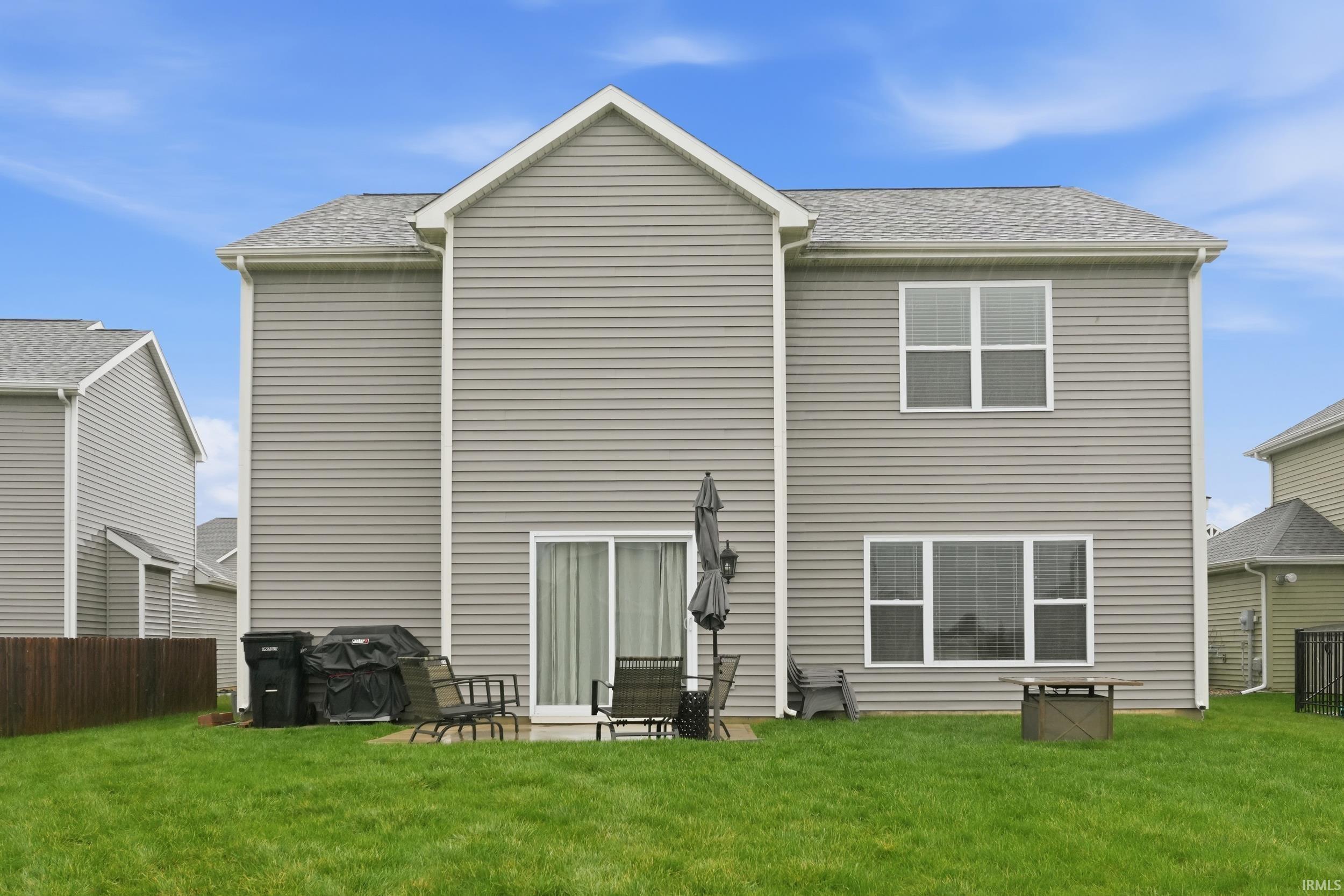 Rear view of house featuring a patio area and roof with shingles