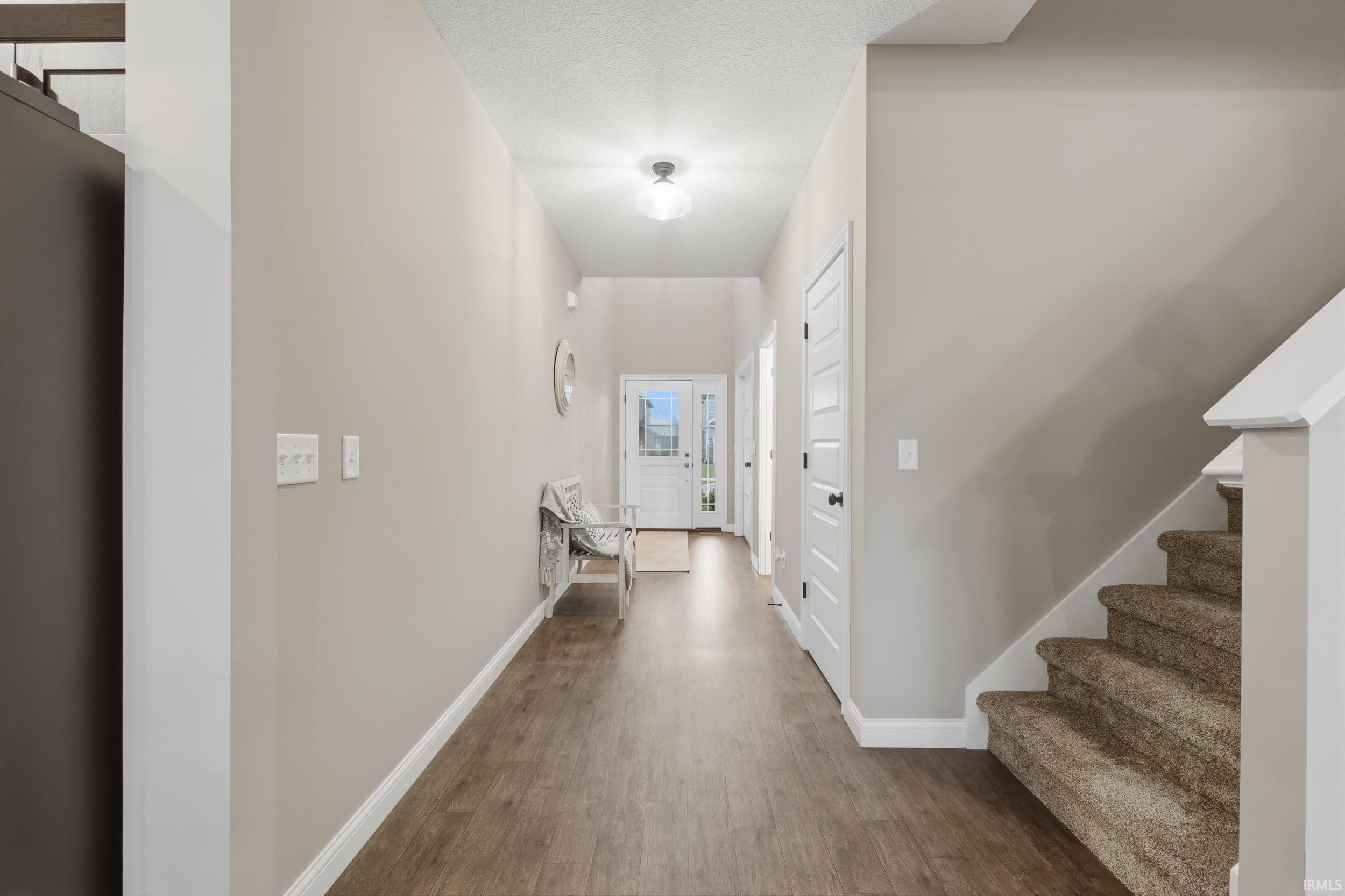 Corridor with dark wood-style flooring and a textured ceiling