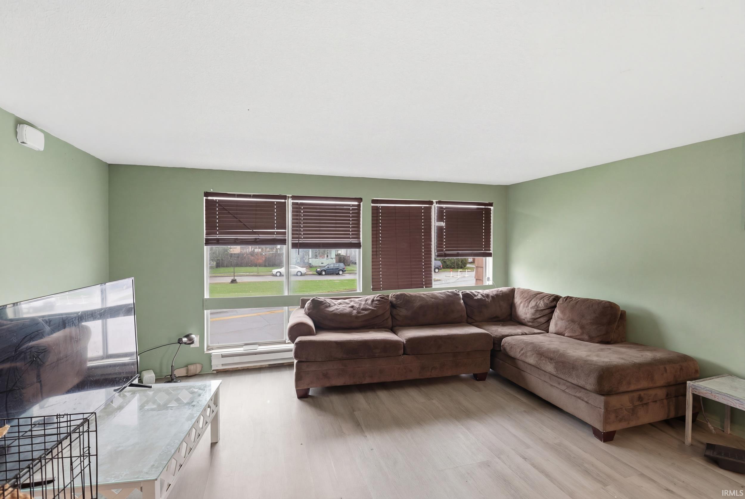 Living room with light wood-style floors and a baseboard heating unit