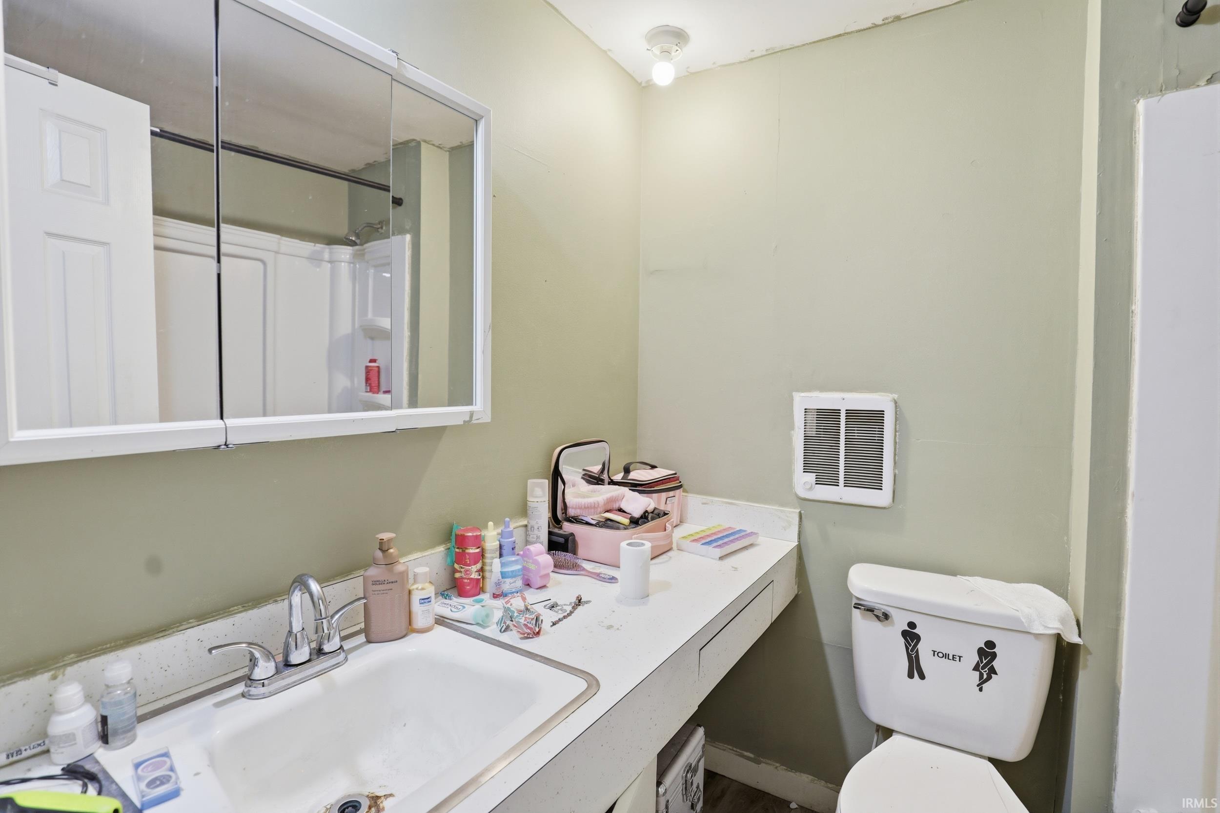 Full bath featuring vanity, heating unit, and a shower