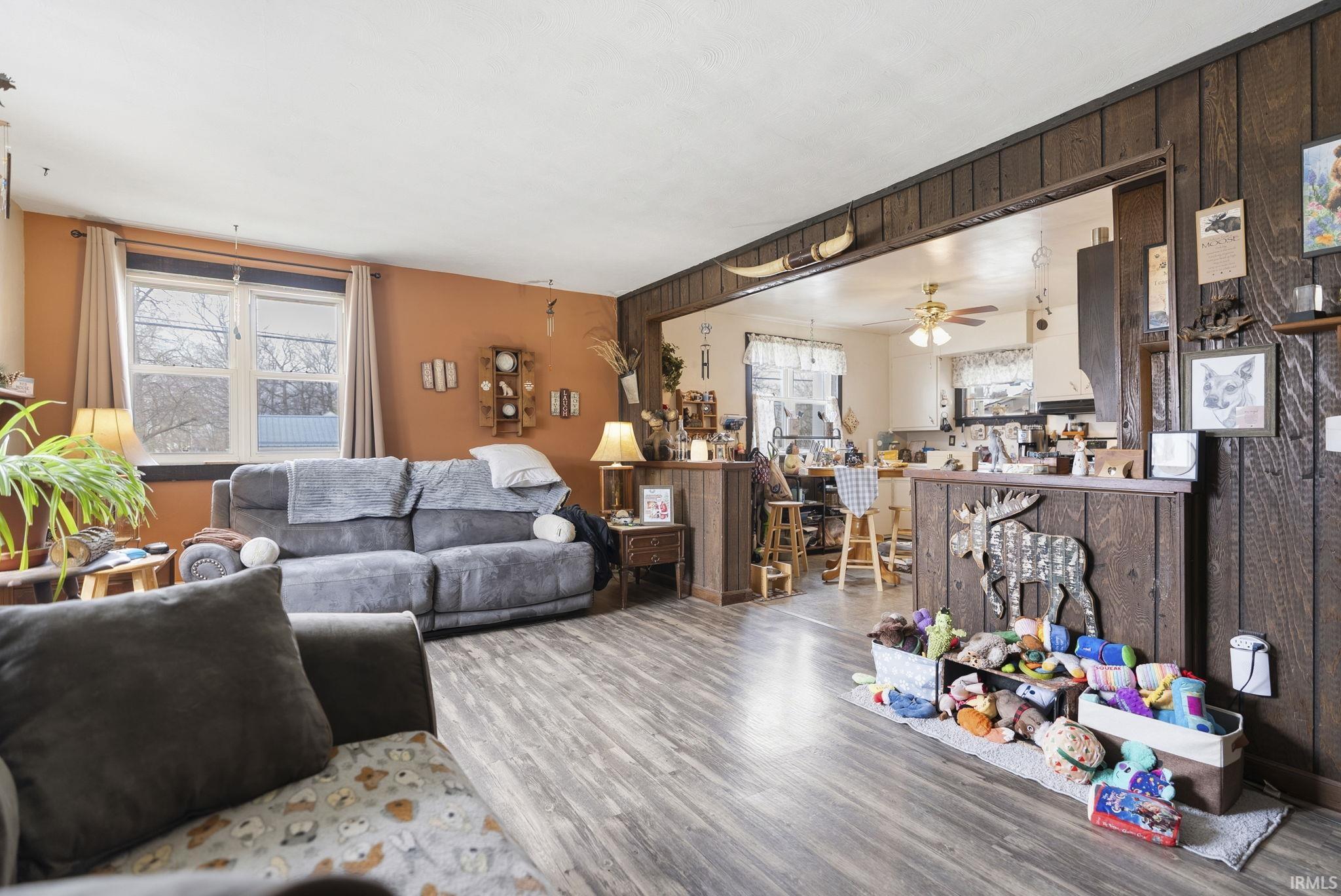Living room with ceiling fan, wood finished floors, and plenty of natural light