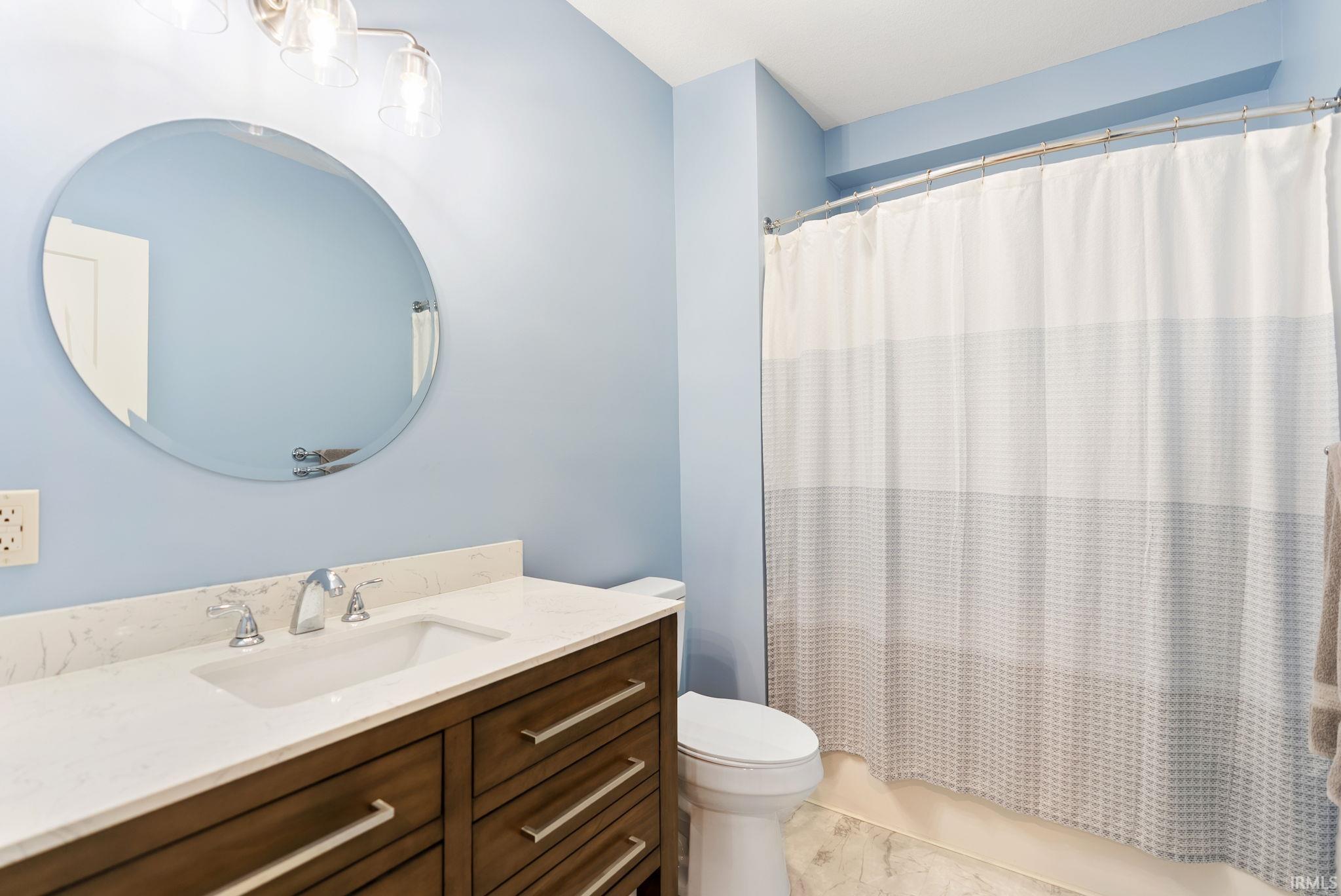 Full bathroom featuring vanity and shower / bathtub combination with curtain