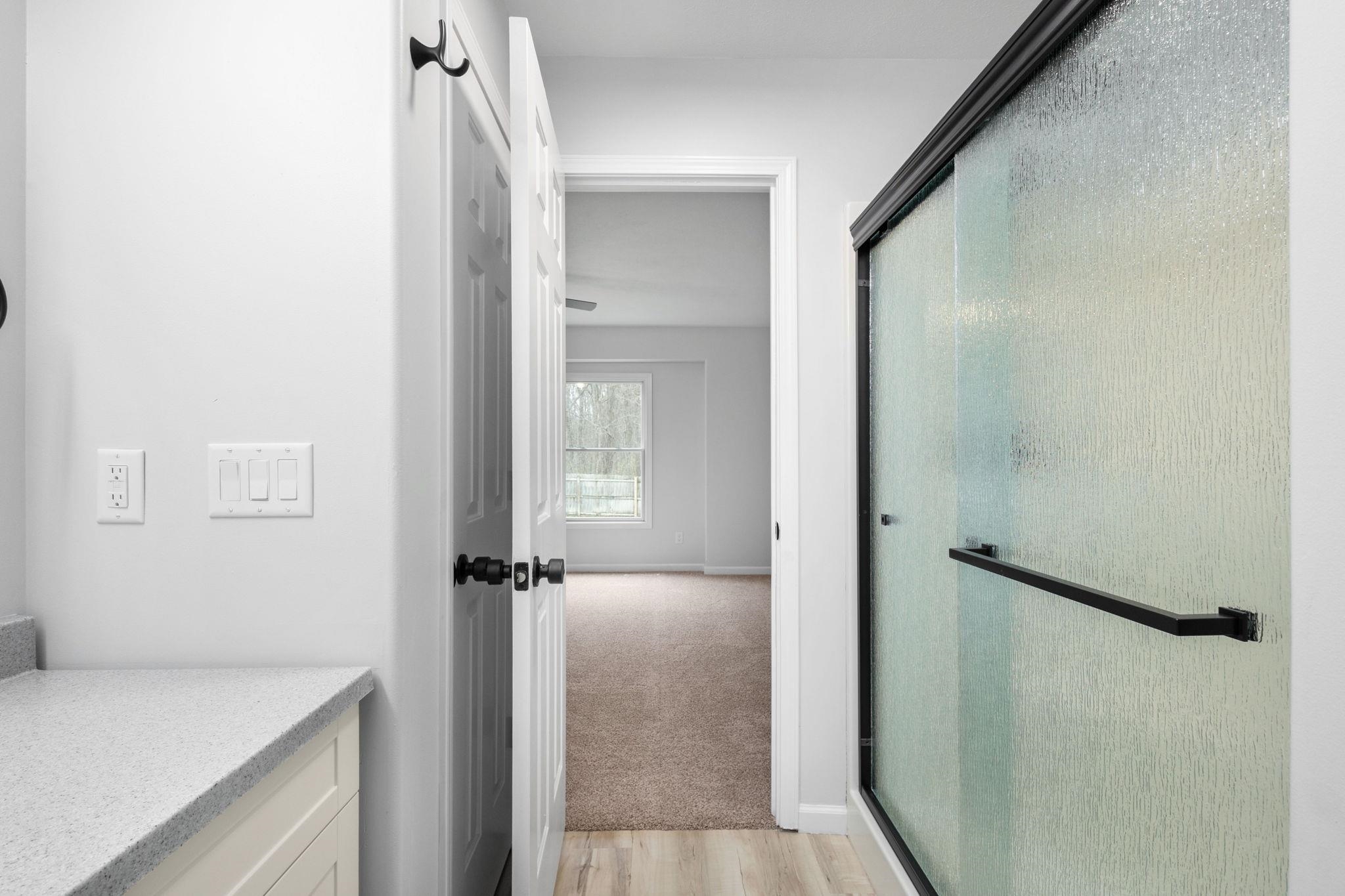 Bathroom with vanity, a shower stall, and light wood finished floors