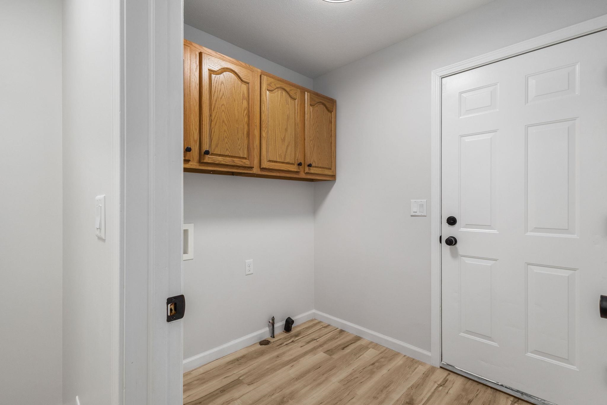 Laundry room featuring cabinet space, light wood-style flooring, and washer hookup