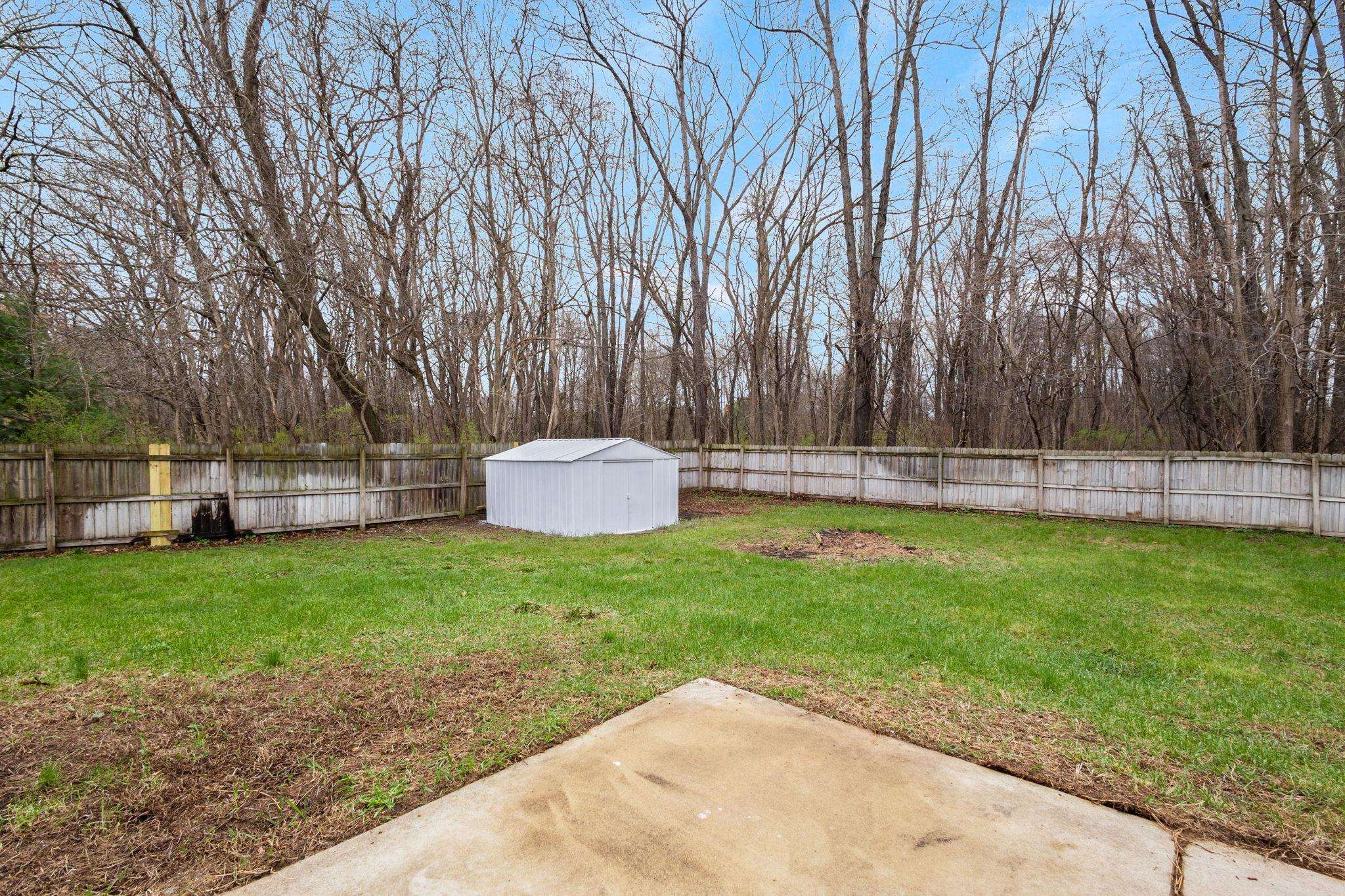 Fenced backyard with a patio and a storage shed