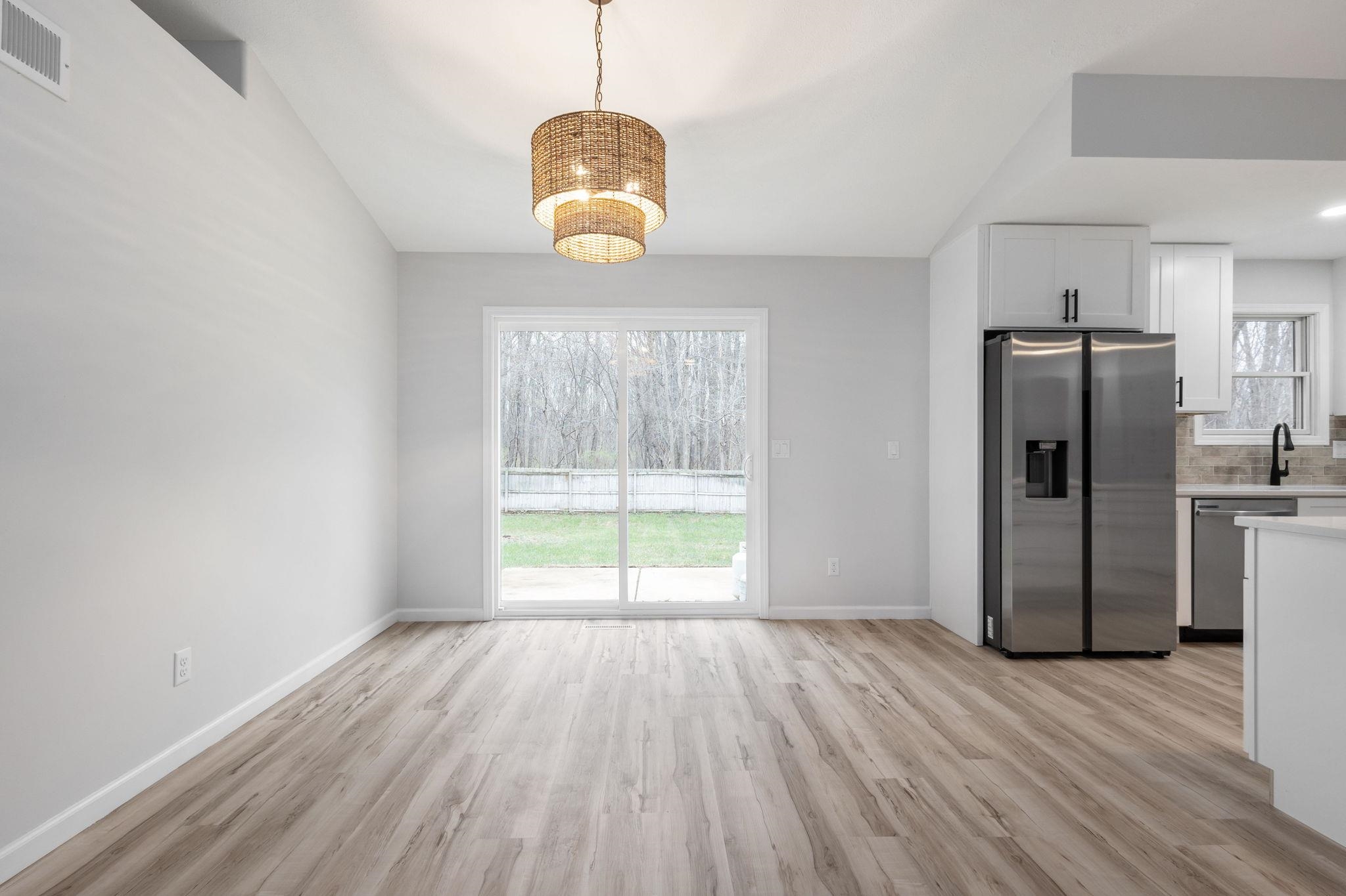 Unfurnished dining area with light wood finished floors and lofted ceiling